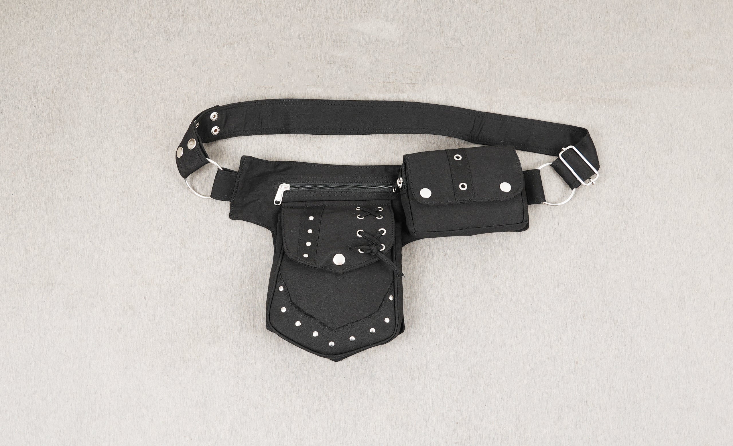 A multi-pocket cotton canvas utility bumbag fanny pack with detailed metal studding.