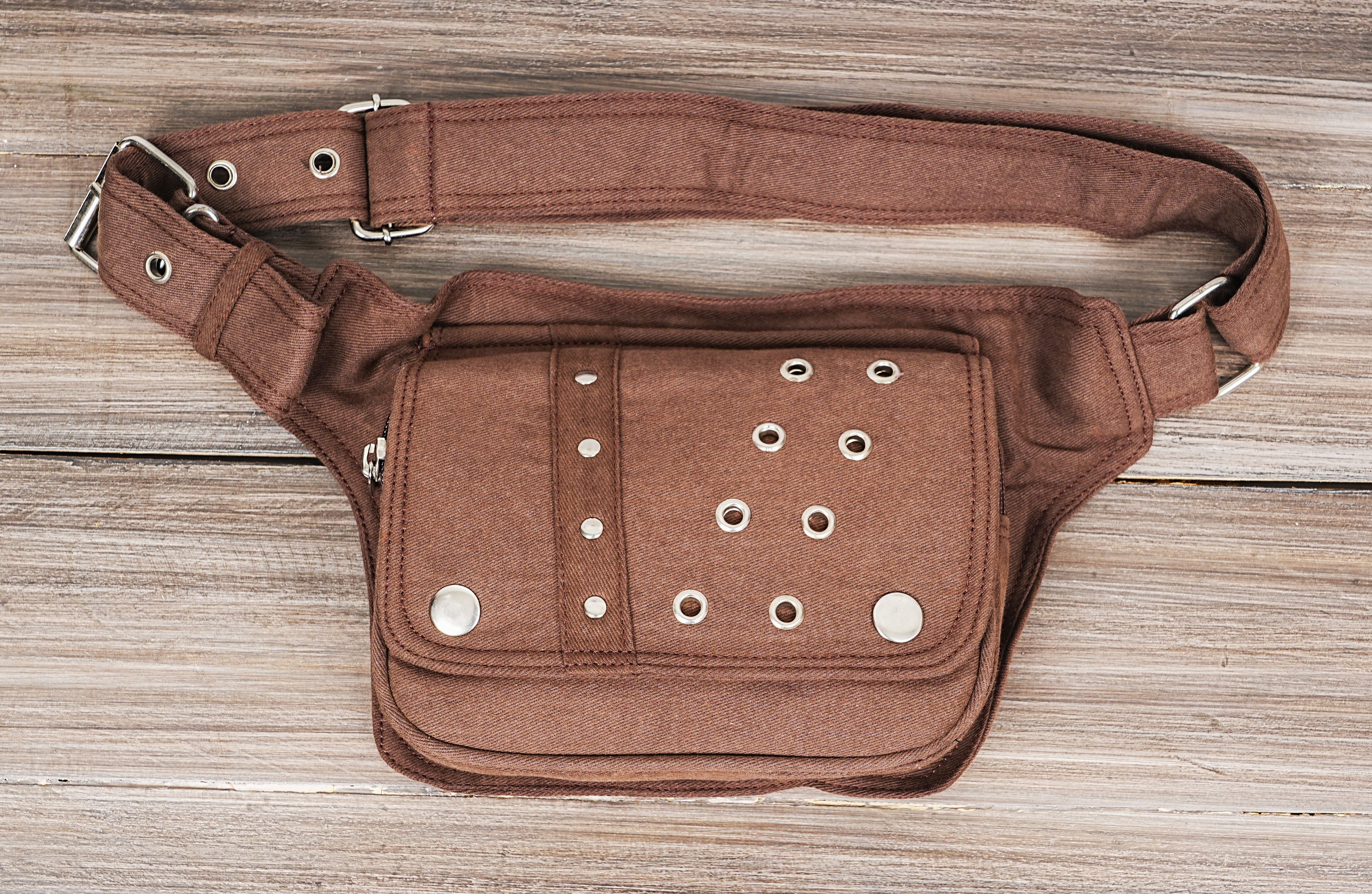 Adjustable canvas bumbag with two pockets and rivet accents.