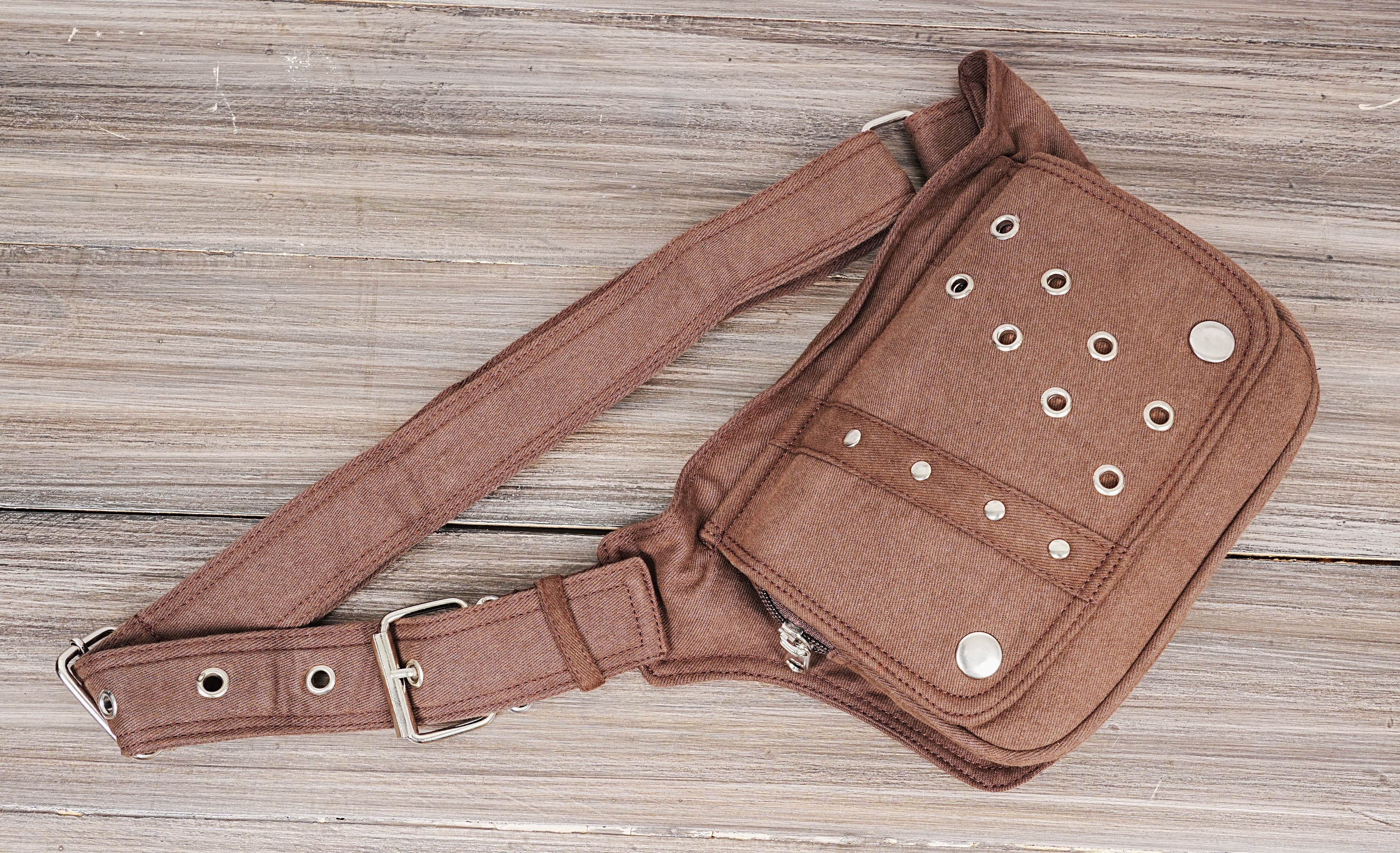 Close-up shot of a men's canvas fanny pack on a wooden background.