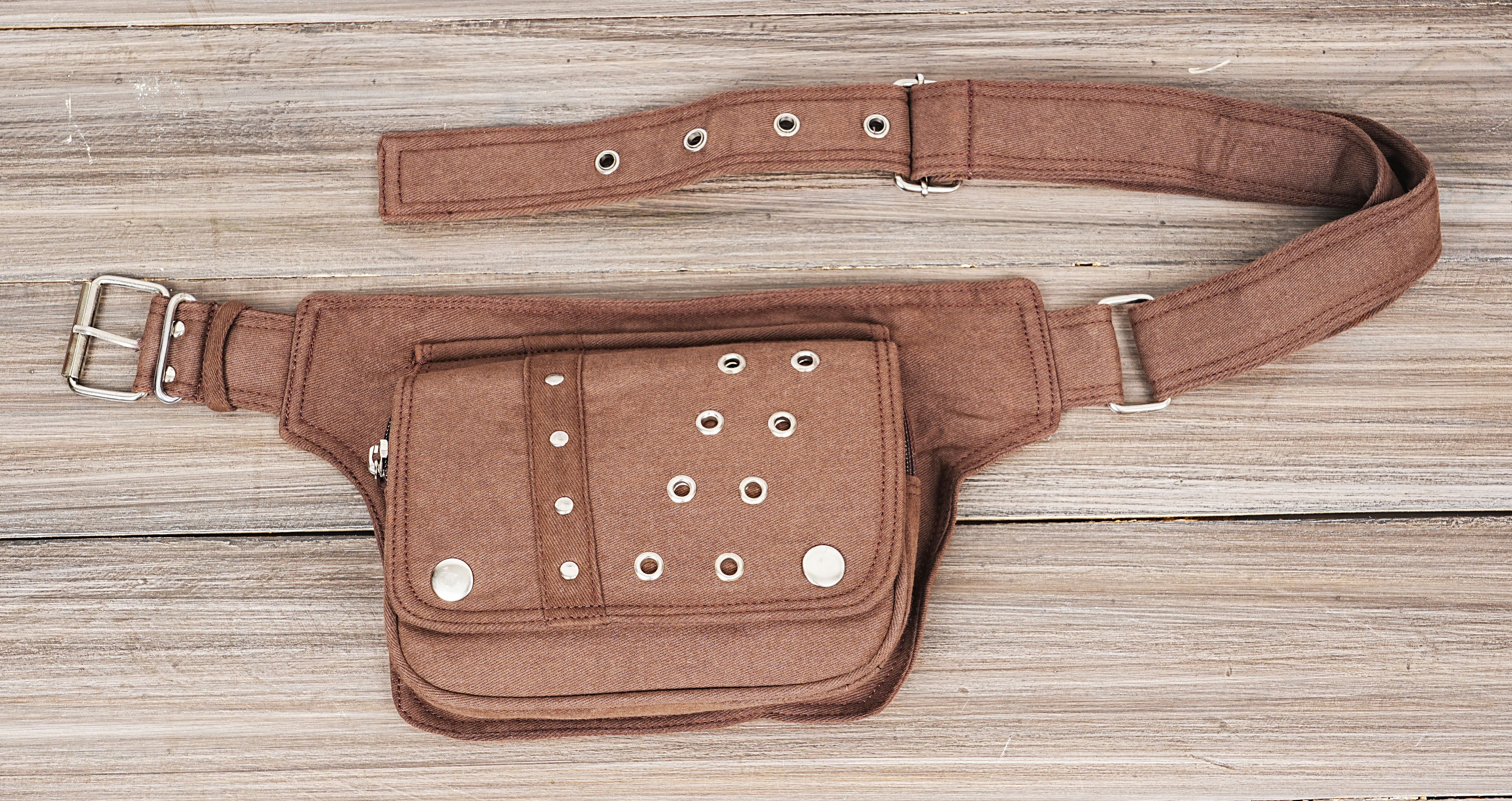 Detailed view of the front pockets of a studded canvas fanny pack.