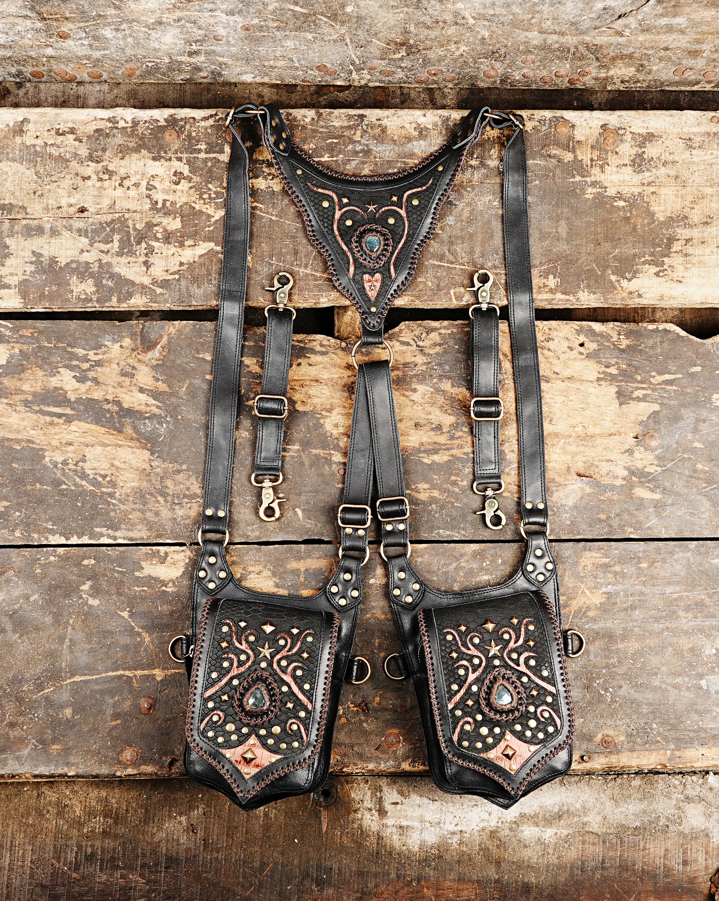 “Black leather double holster with copper tribal patterns and gemstone accents”
