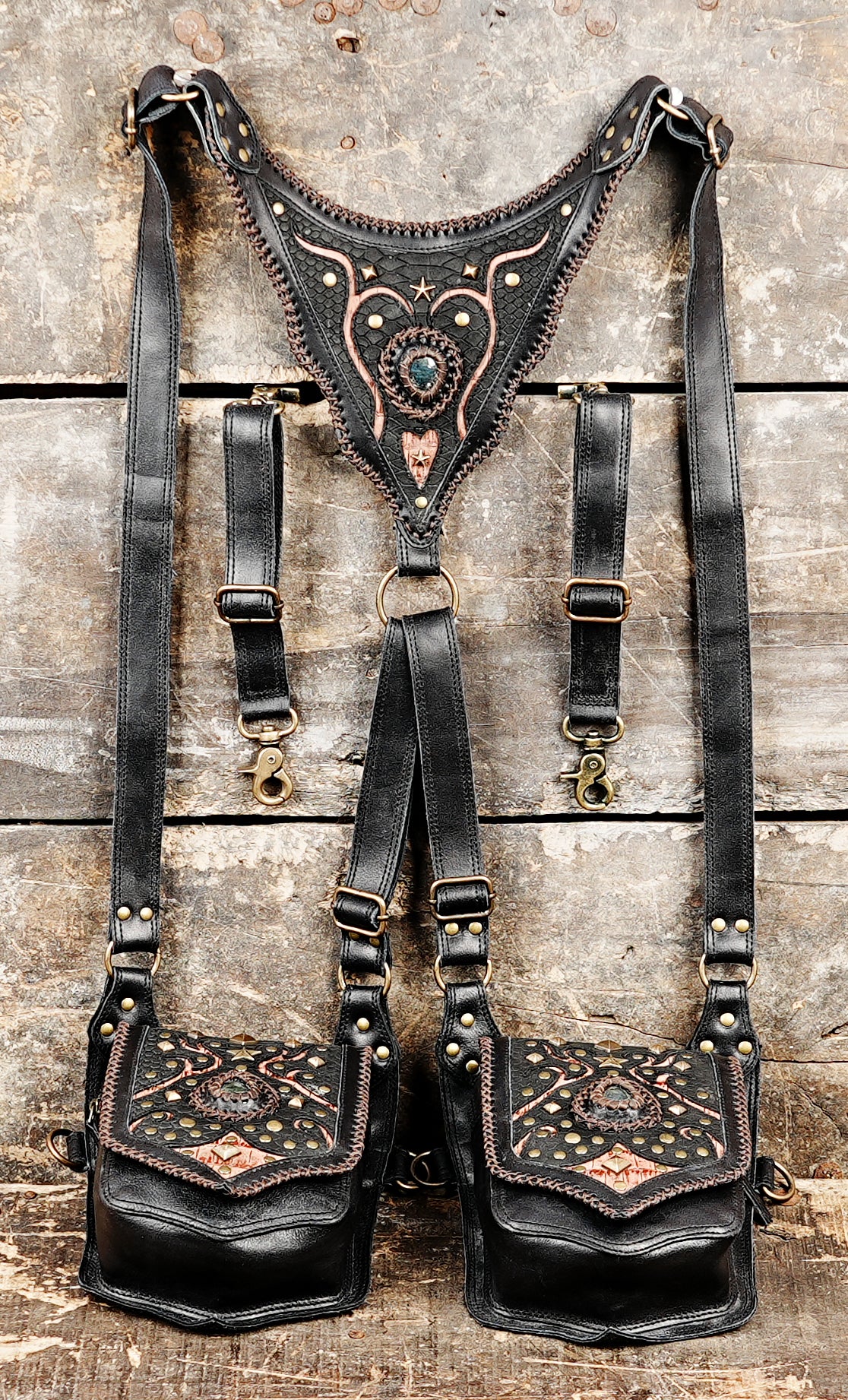 “Handmade leather double holster with intricate tribal stitching and stone front”