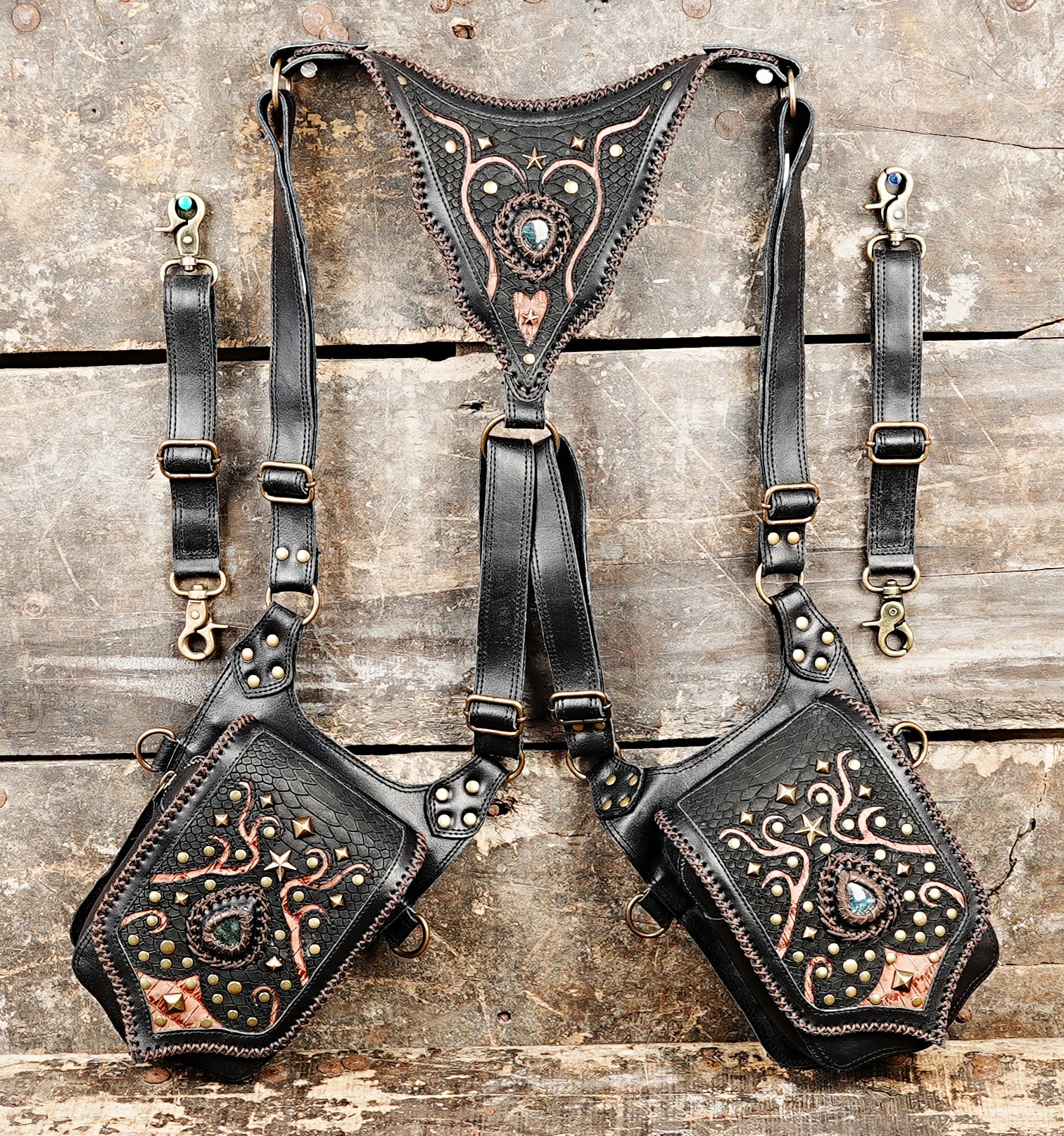 “Black crossbody holster with tribal carvings and decorative gemstone flap”