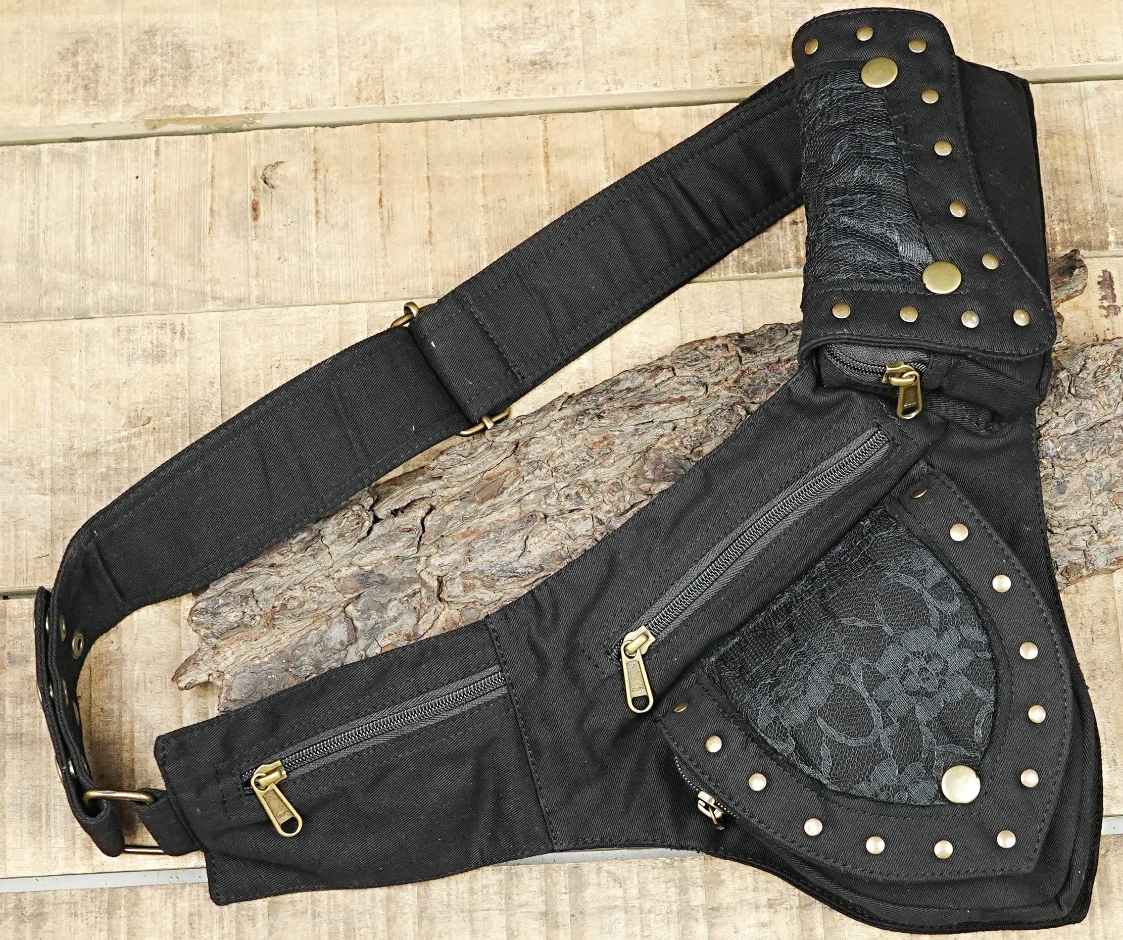Multi-pocket festival hip pack with dark lace insets on rustic wooden background