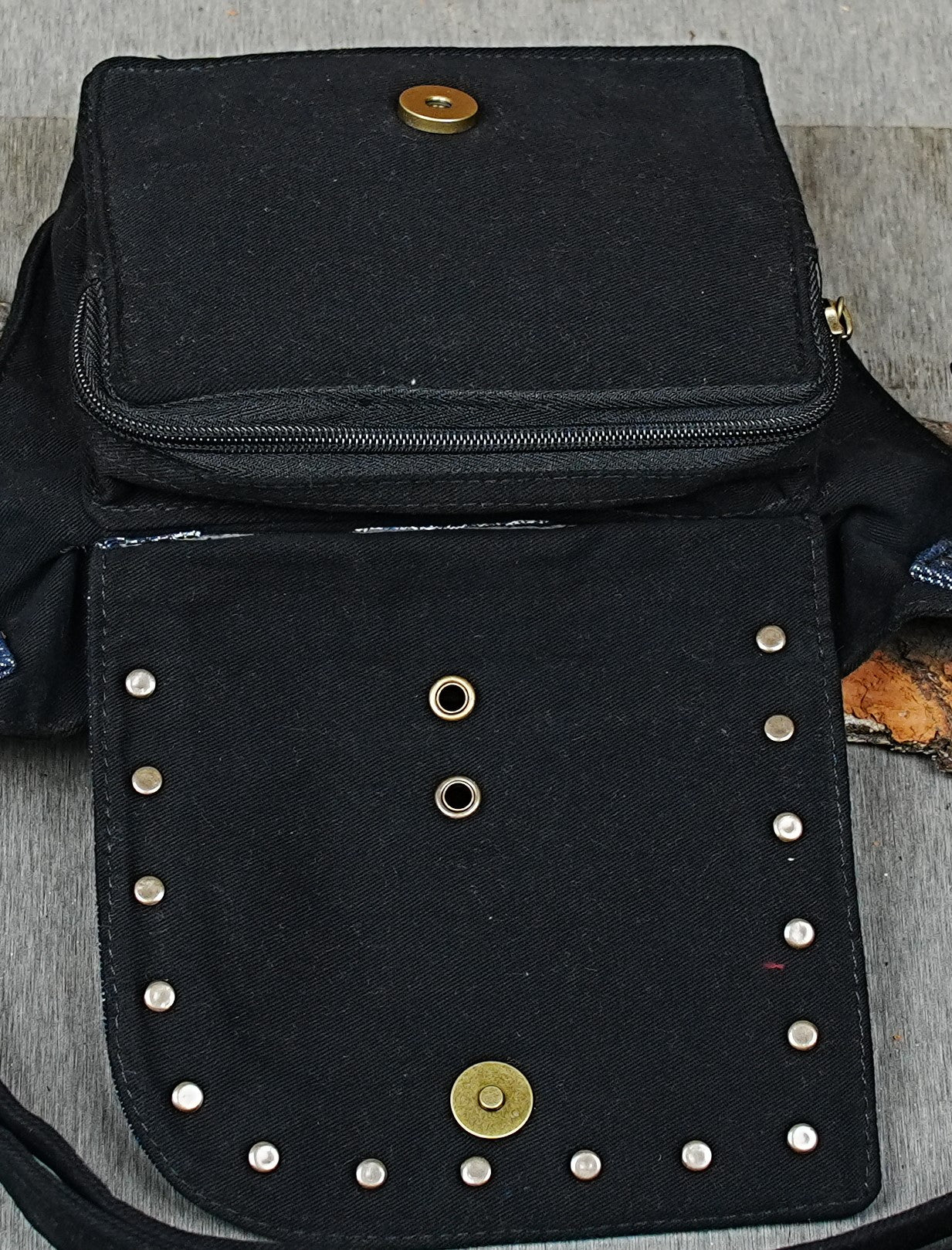 Compact black waist pouch with blue denim detail and hidden zipper pocket