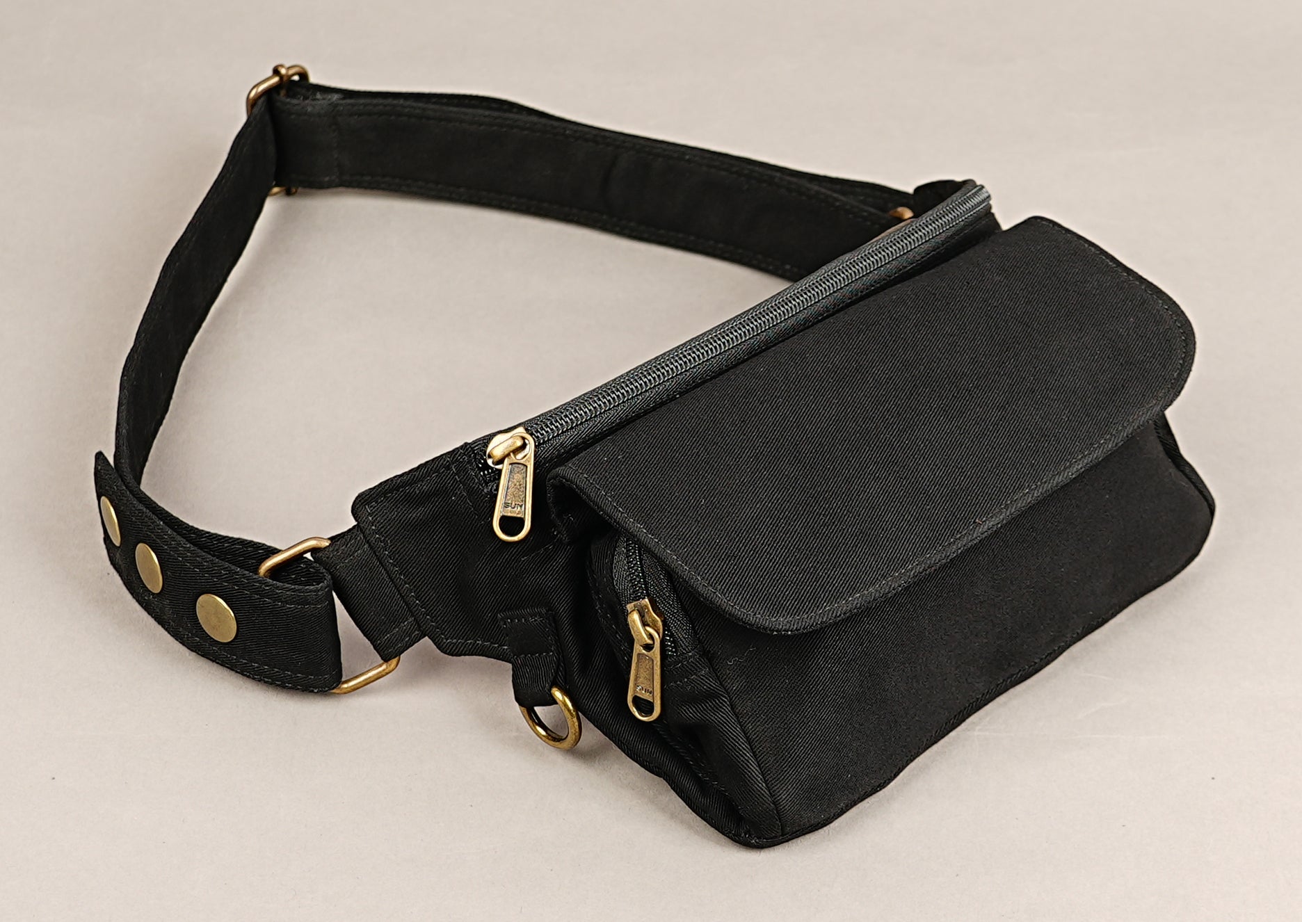 Black cotton travel waist bag with spacious pockets and brass hardware