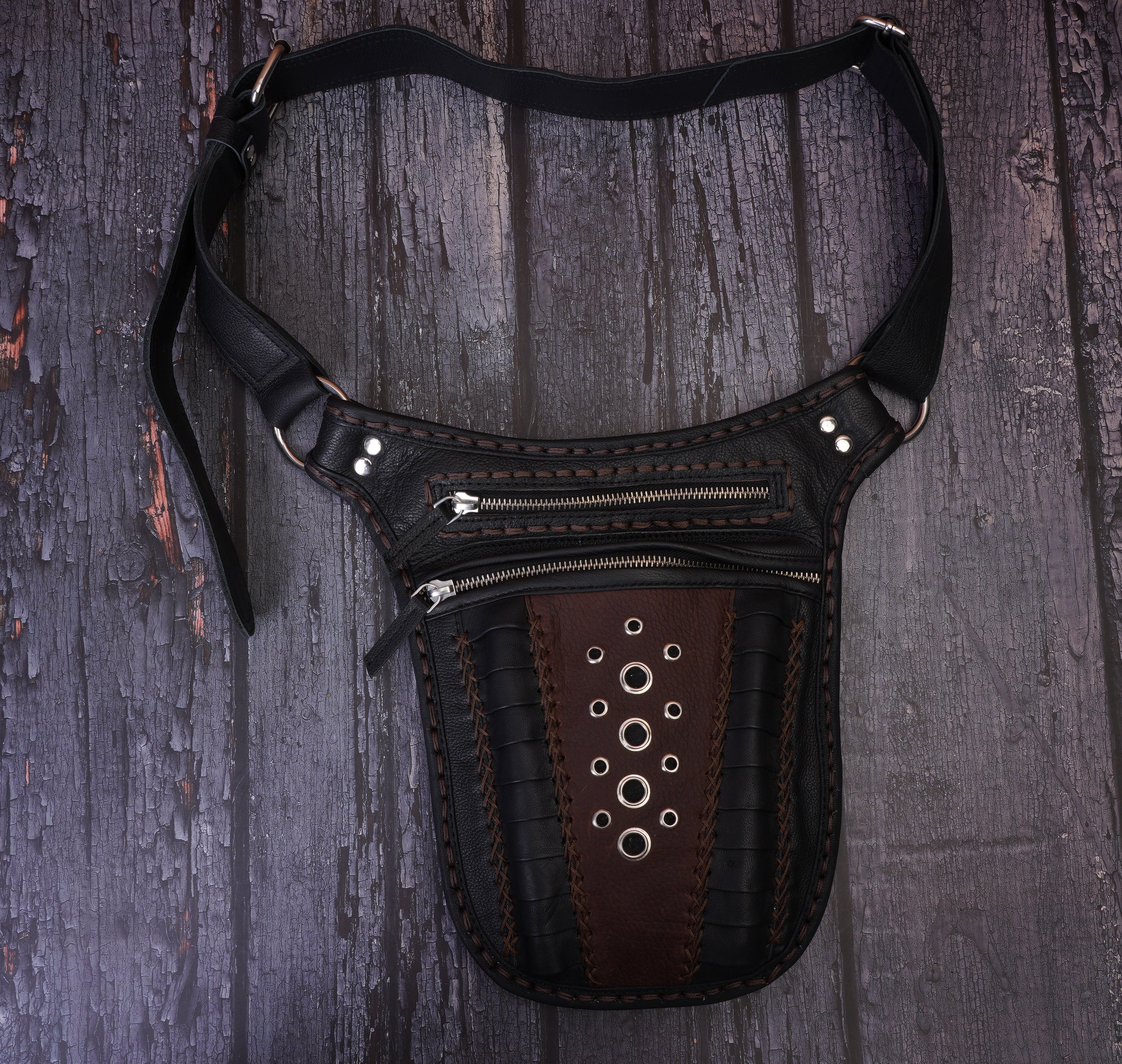 Handcrafted black leather hip bag with dual zippered compartments,