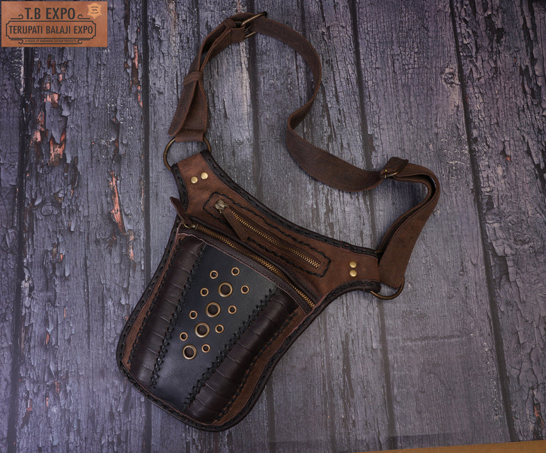 Handmade brown leather hip bag with zipper pockets and brass ring details.