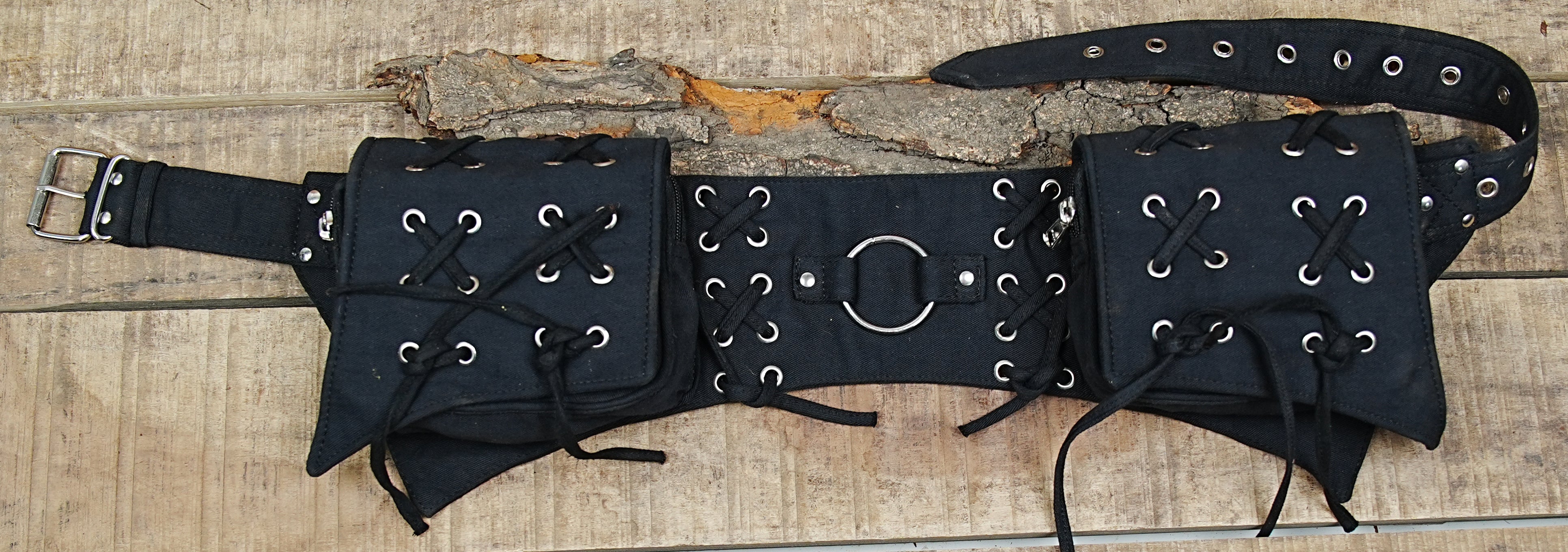 A close-up view of a black cotton utility fanny pack with two multi-purpose pouches, laid flat.