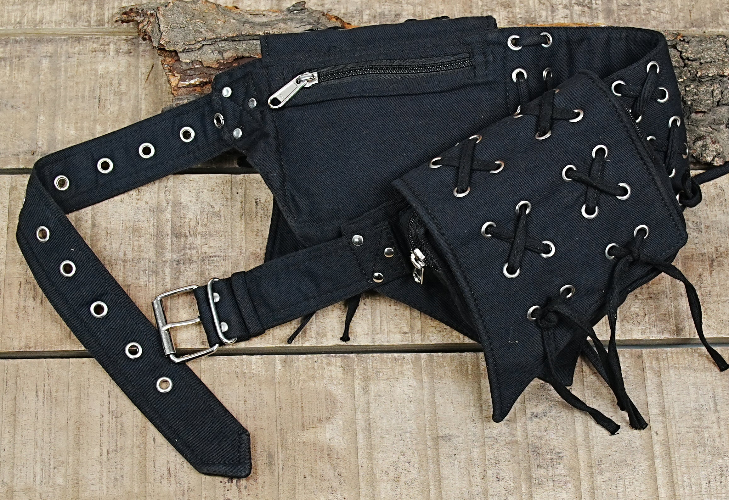 Multi-compartment hip pack in black heavy-gauge cotton canvas, shown against a neutral concrete texture.