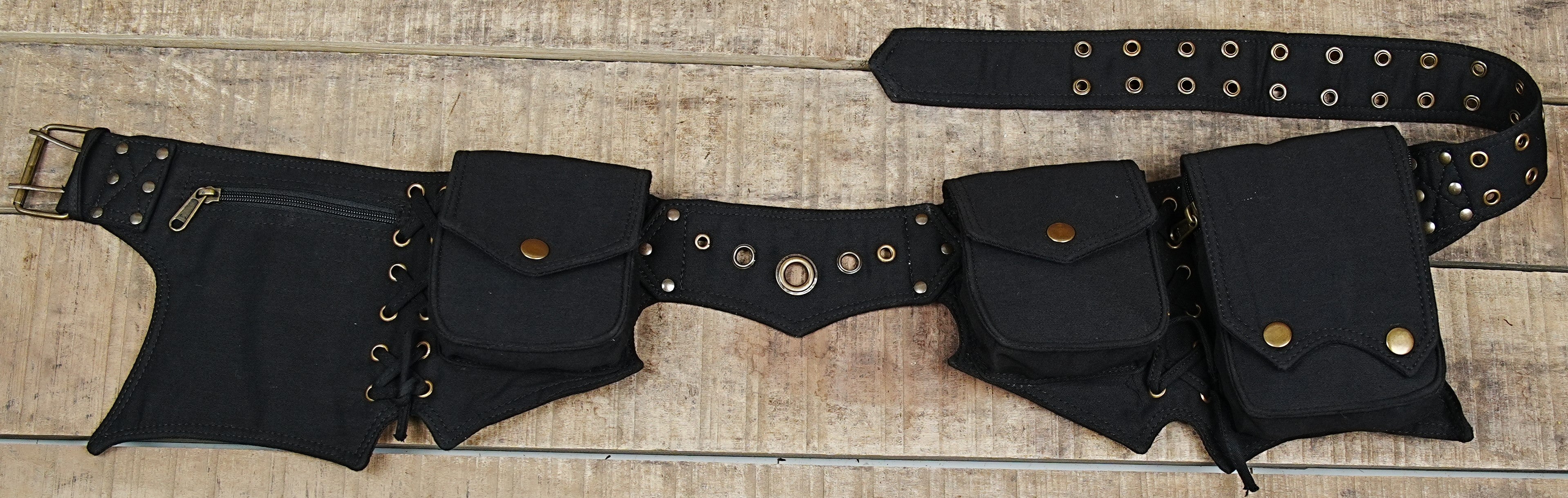 Handmade black canvas pixie utility belt with brass eyelets and snap pockets laid flat