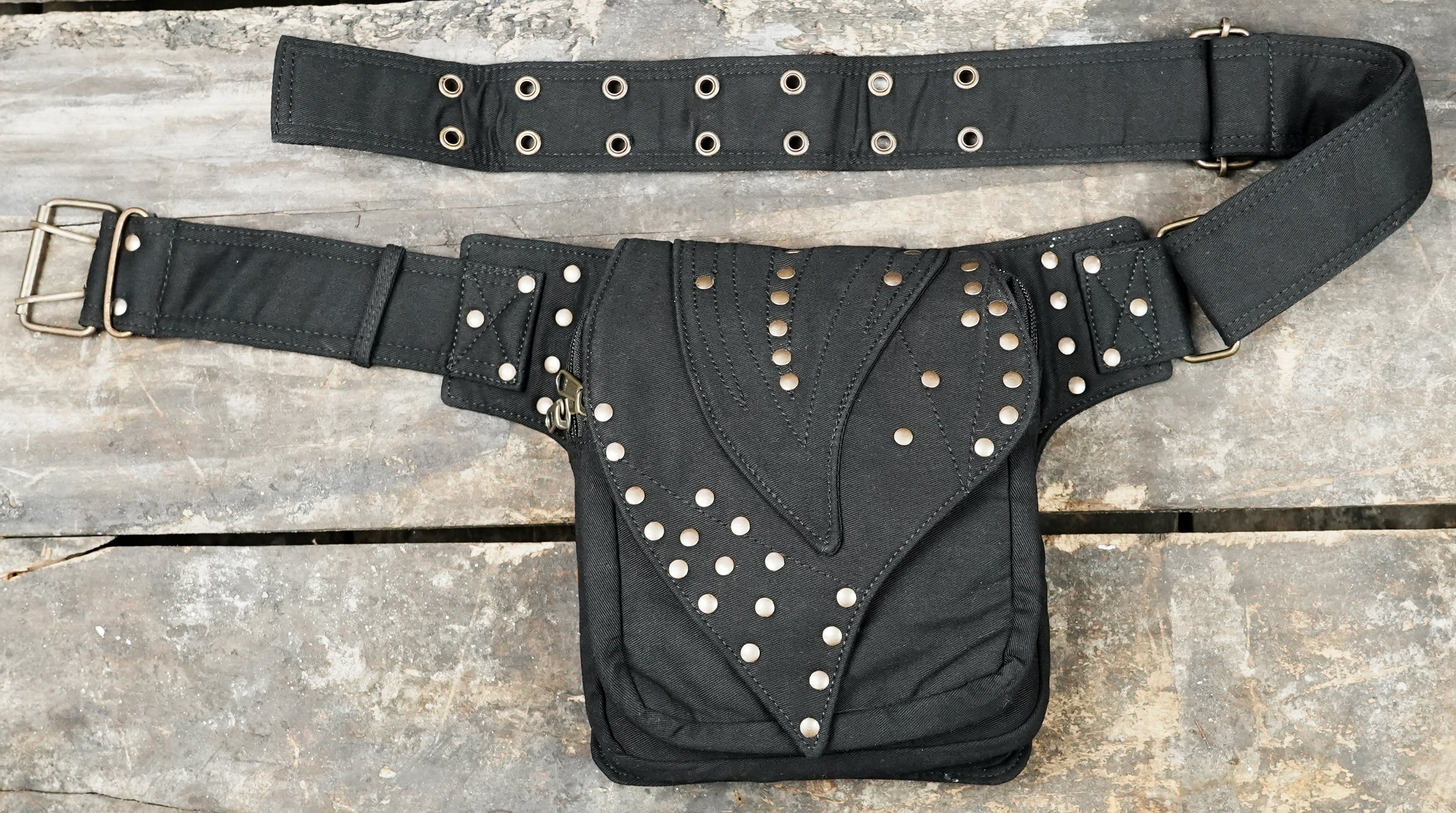 Steampunk canvas hip pouch with studded wing pattern on rustic wood