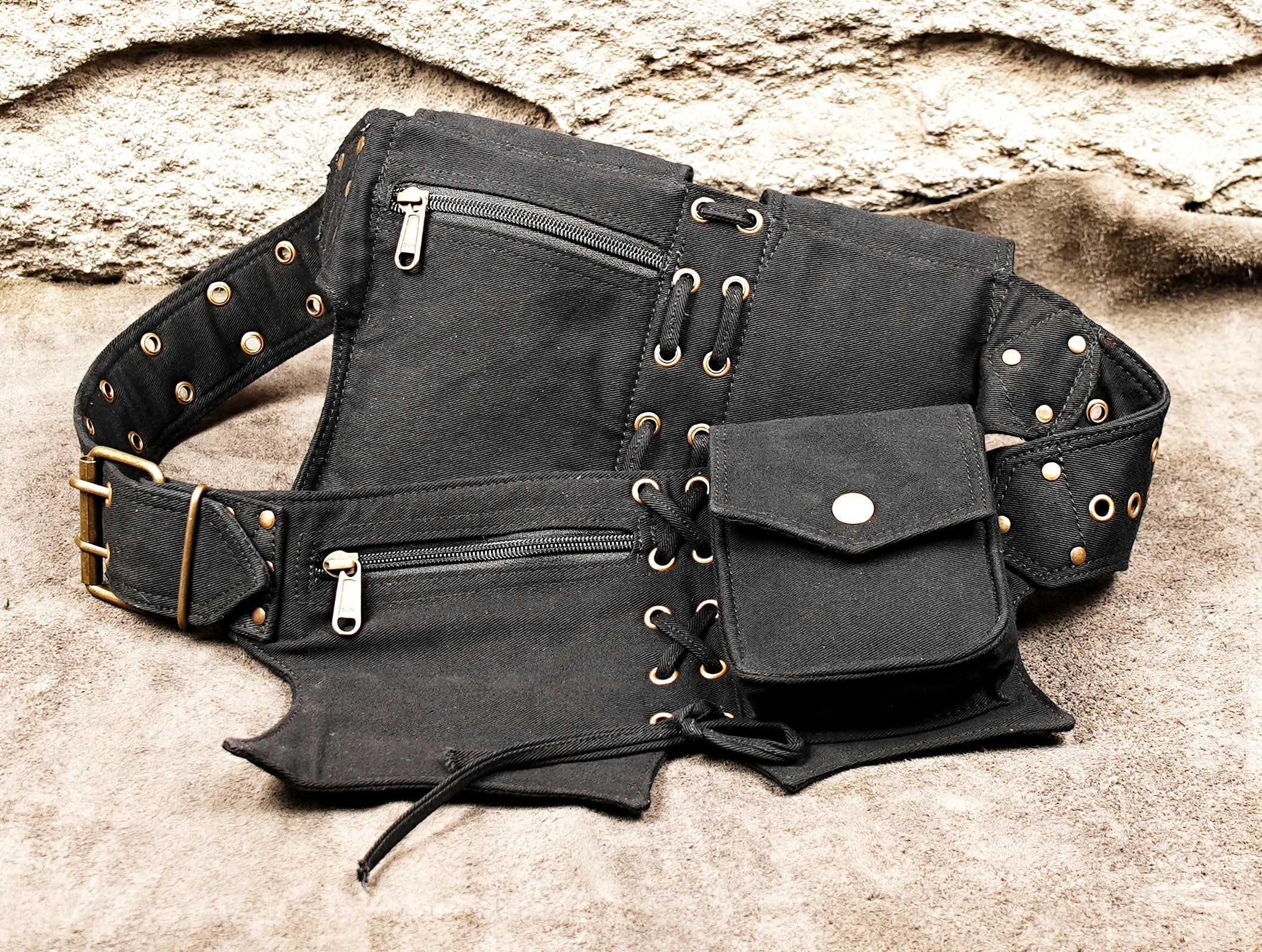 utility belt with four visible pouch sections, snap buttons, eyelets and zipper detail