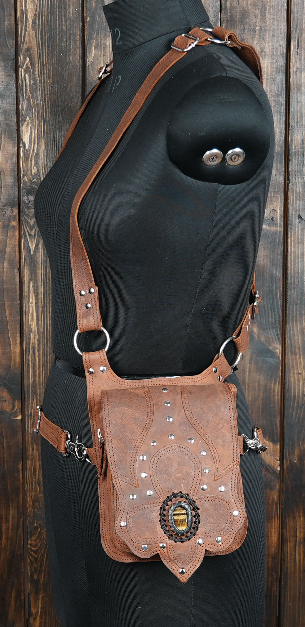 Detailed handmade leather holster bag featuring riveted patterns and gemstone trim