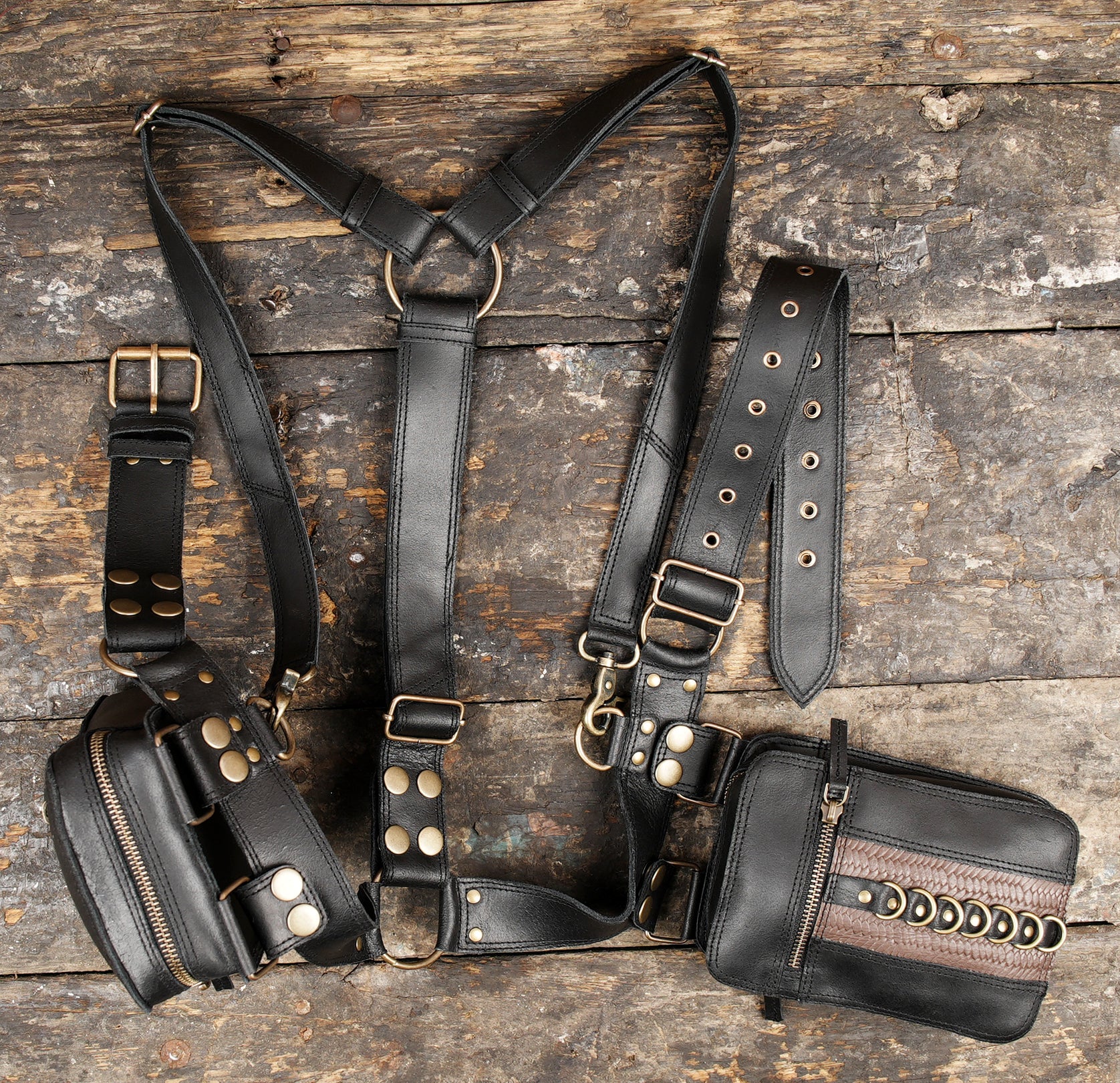 "Black leather hip holster with brass rivets and zipper pockets"