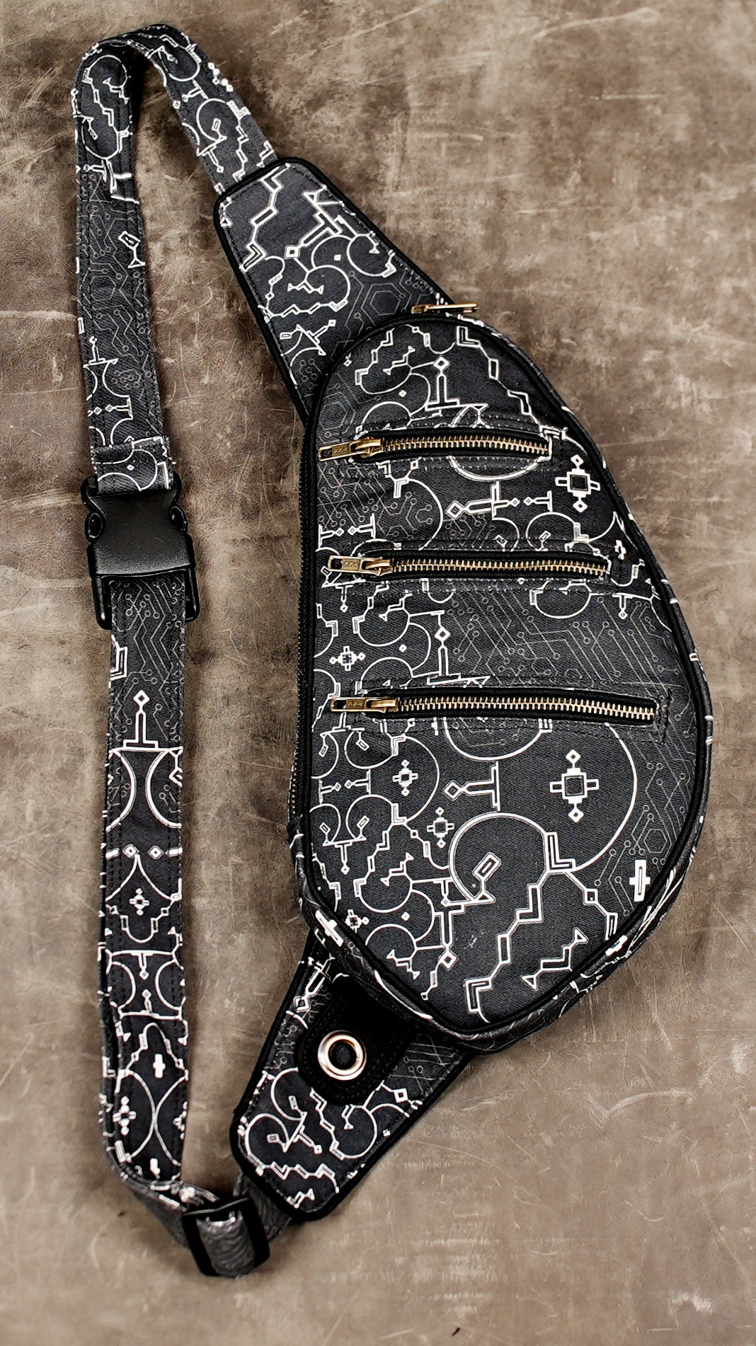 Hands-free crossbody bag with three front zip pockets, black print
