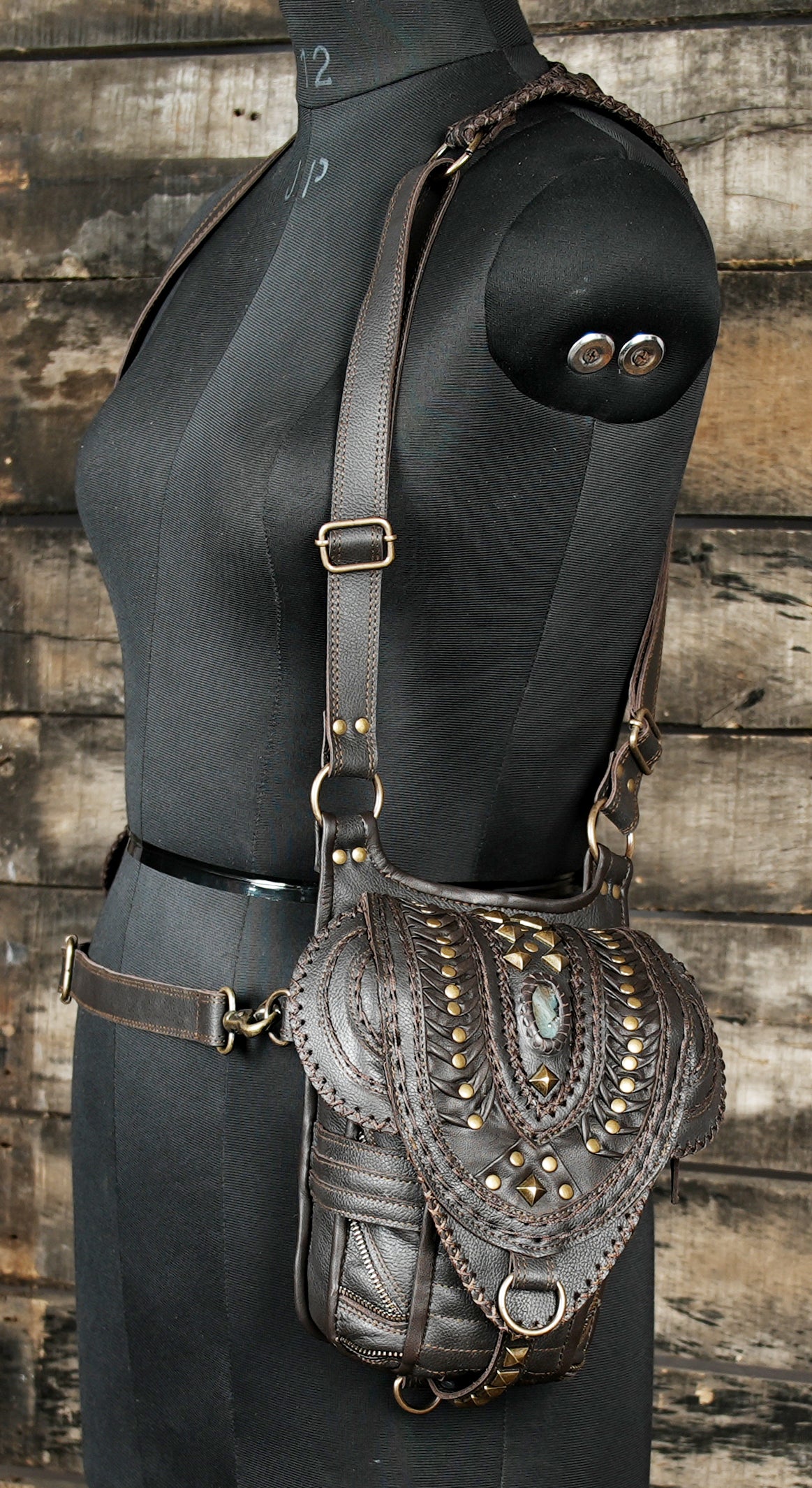 “Premium brown leather shoulder rig with gemstone focal point and carved patterns”
