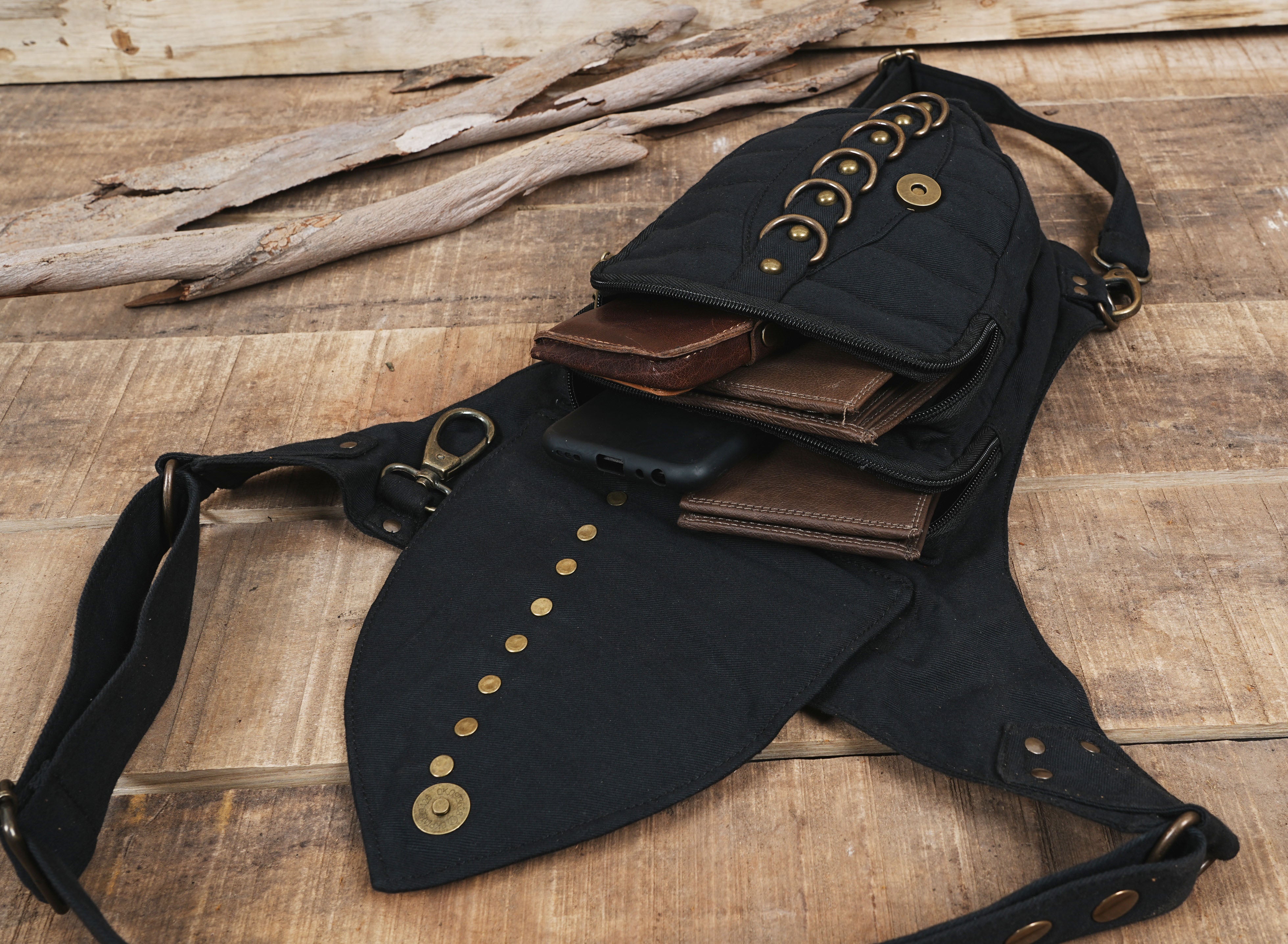 Alternative streetwear side pouch bag in black canvas with brass ring accent.