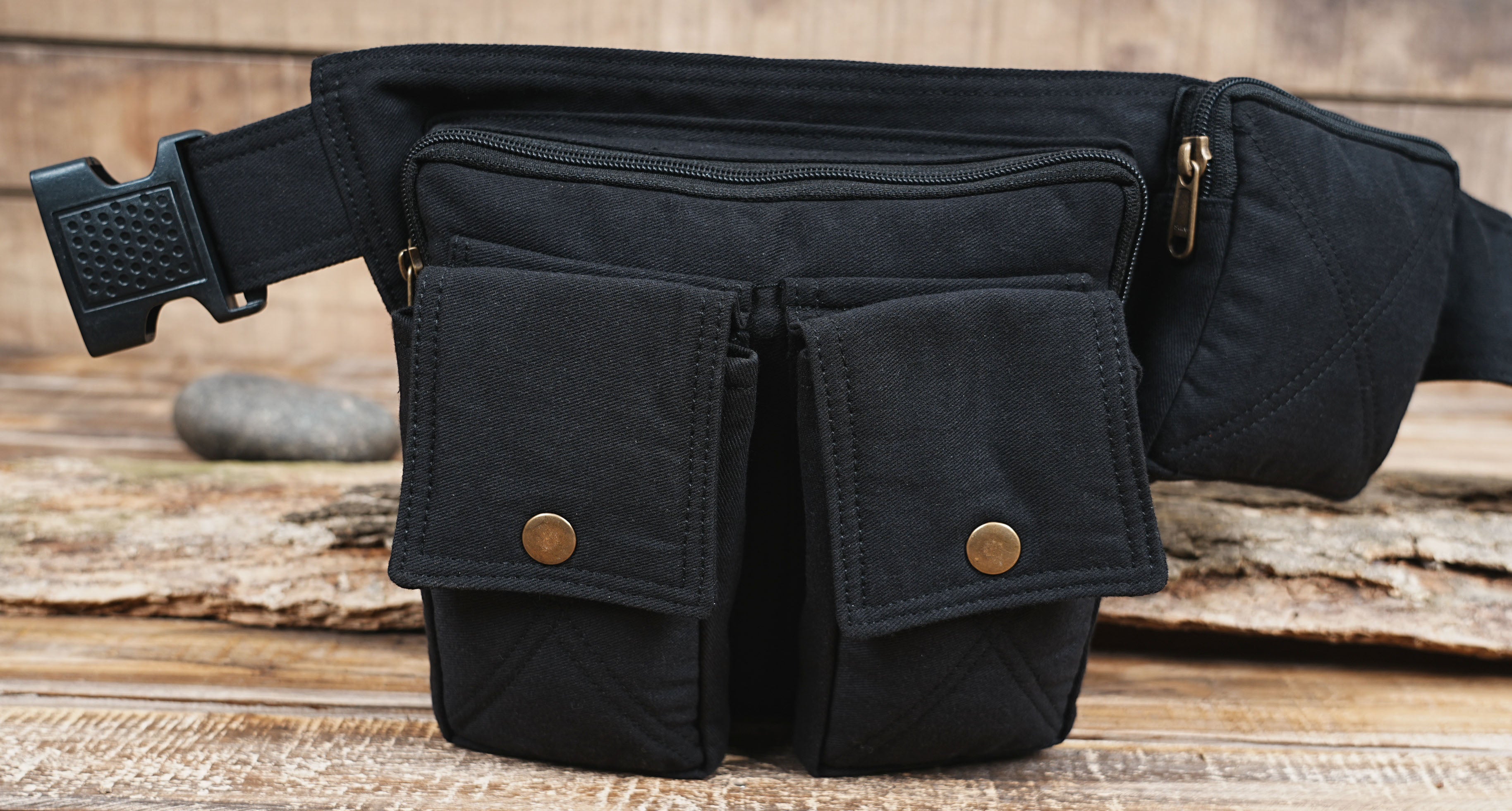 Close up of front pockets with brass snap buttons on black fanny pack