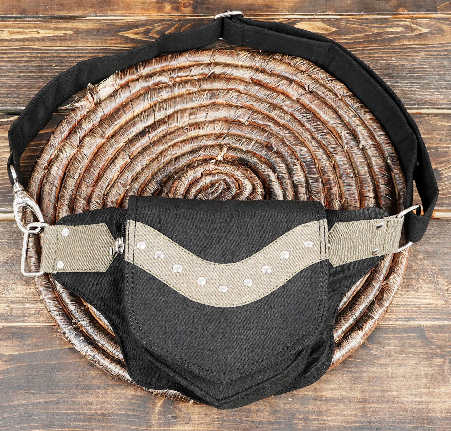 Close-up of the black and grey cotton fabric texture and sturdy stitching on a bumbag.