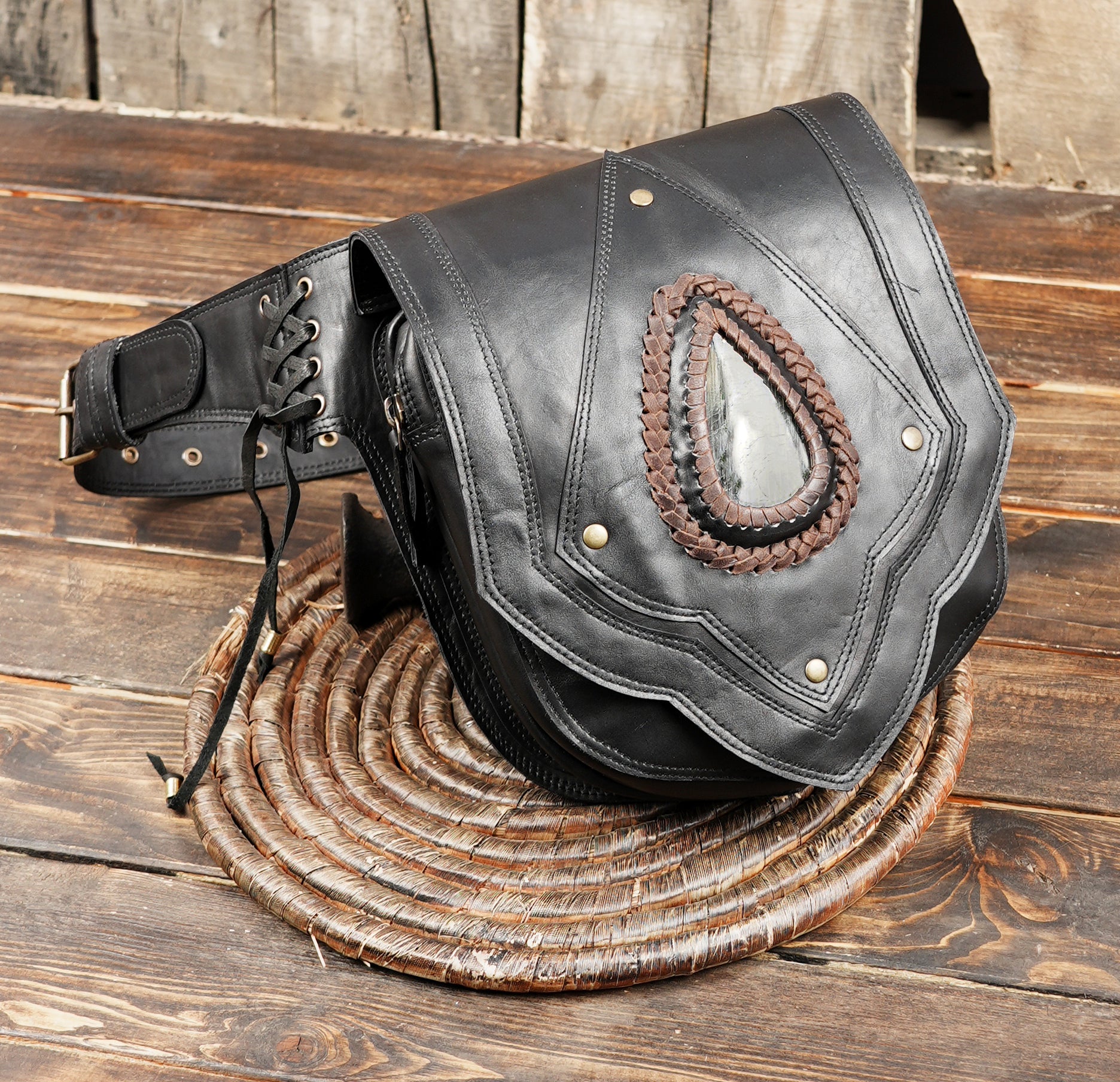 Black leather waist pouch with braided trim and gemstone
