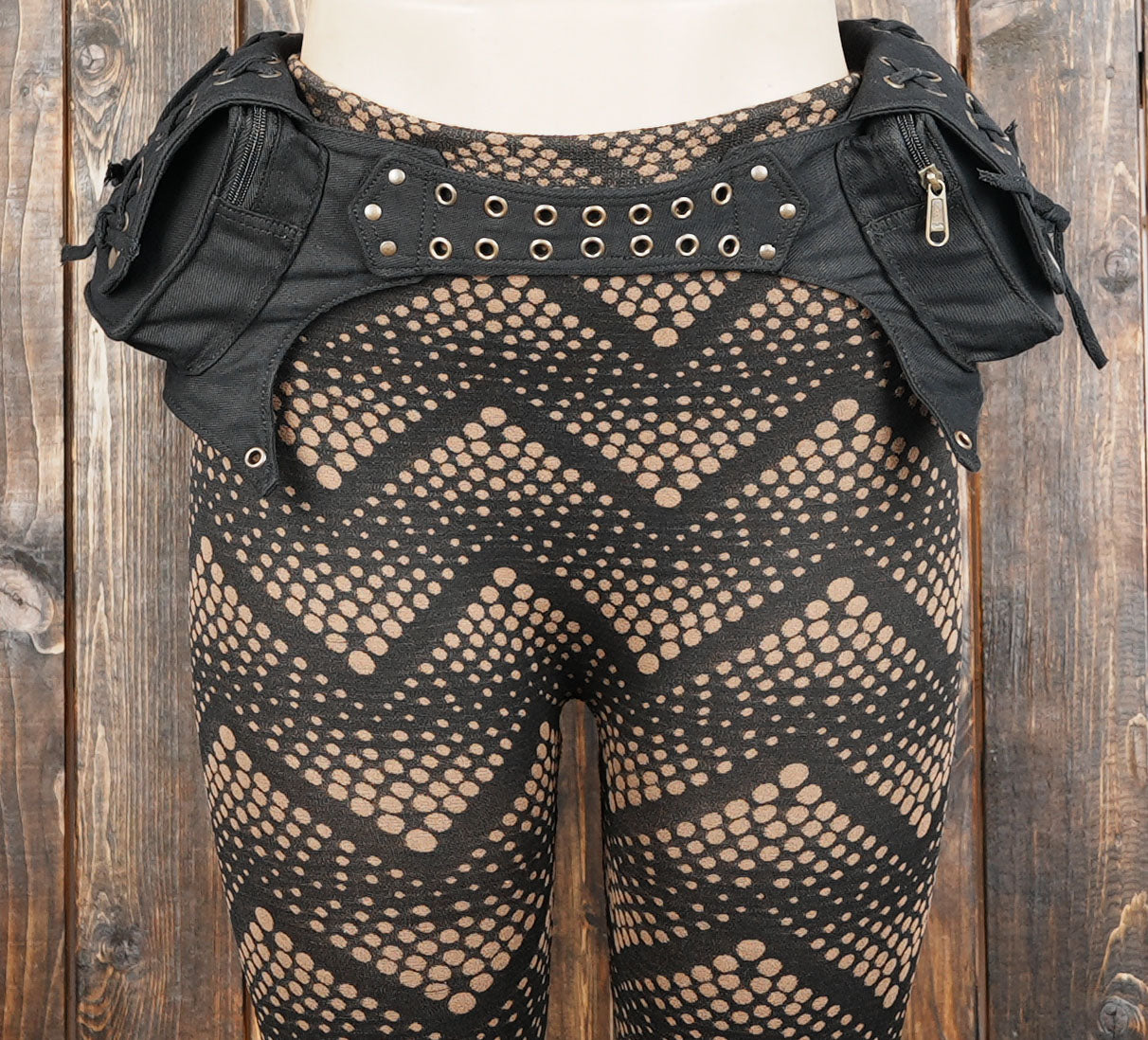 Black cotton utility belt with cargo storage pouches and grommet details for festivals.