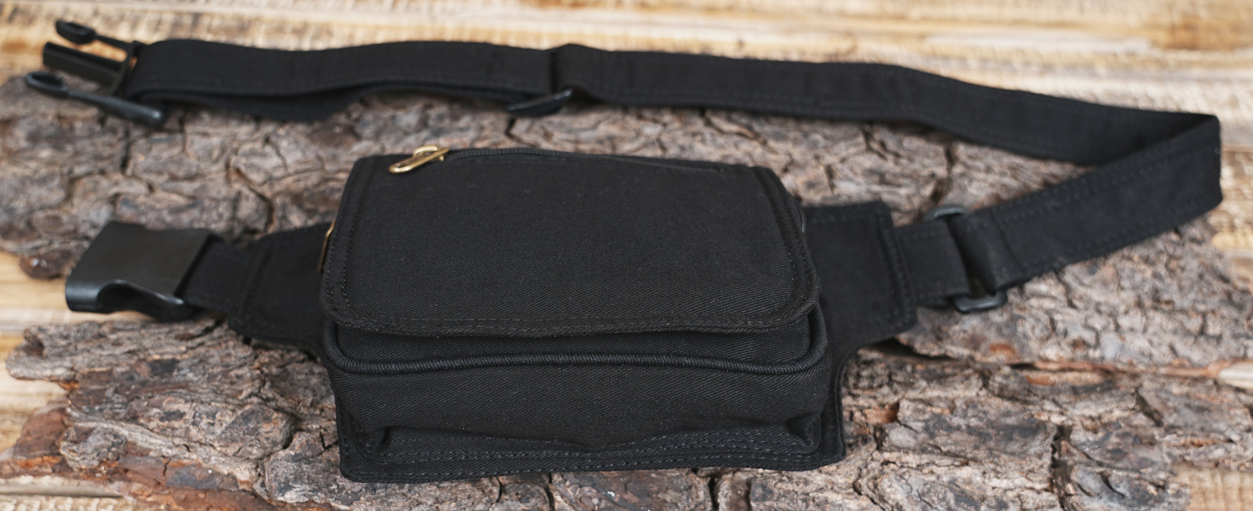 Minimalist black hip bag attached to an adjustable waist strap with a plastic buckle.