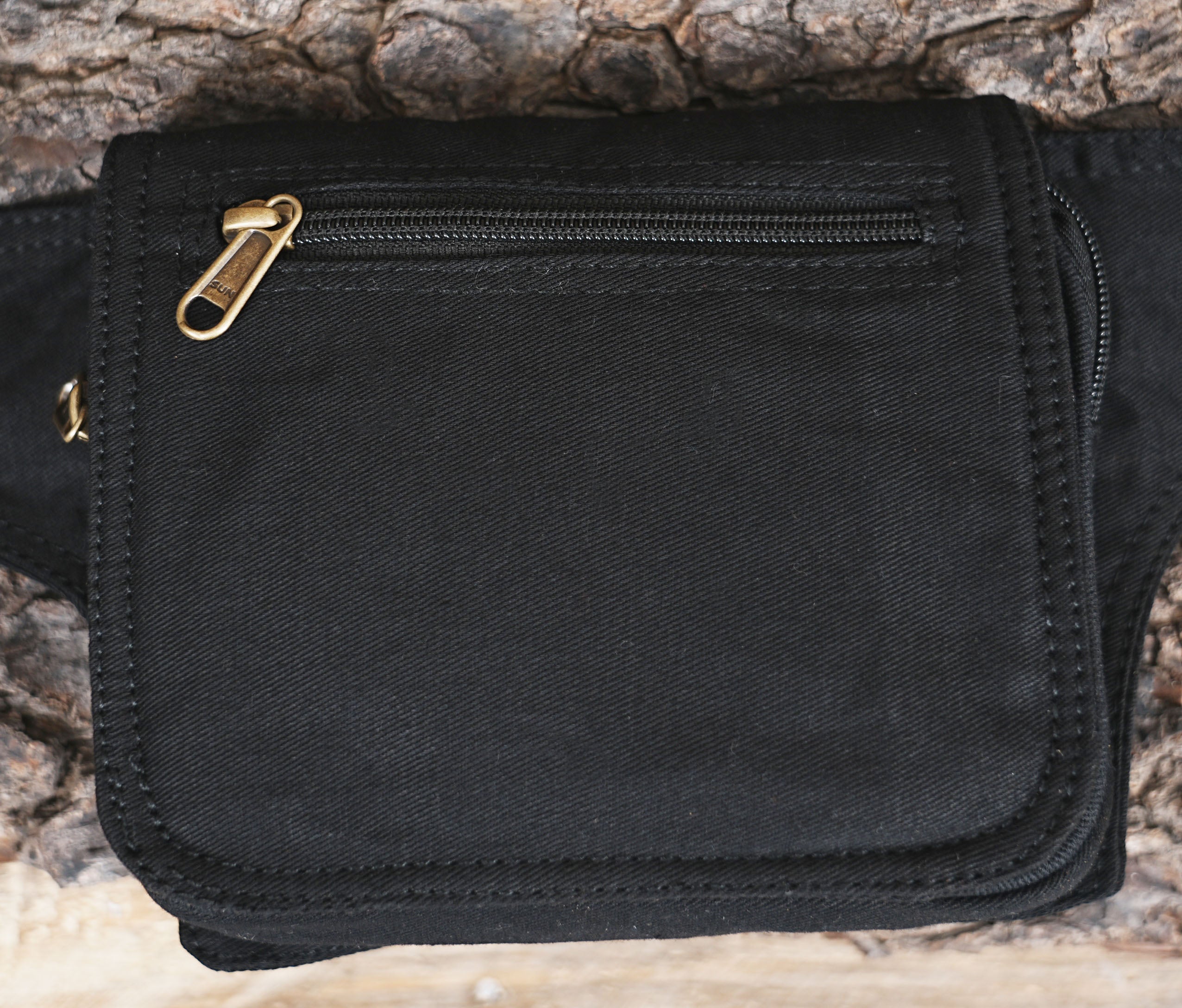 Adjustable waist pack made of durable black fabric with secure zipper compartments.