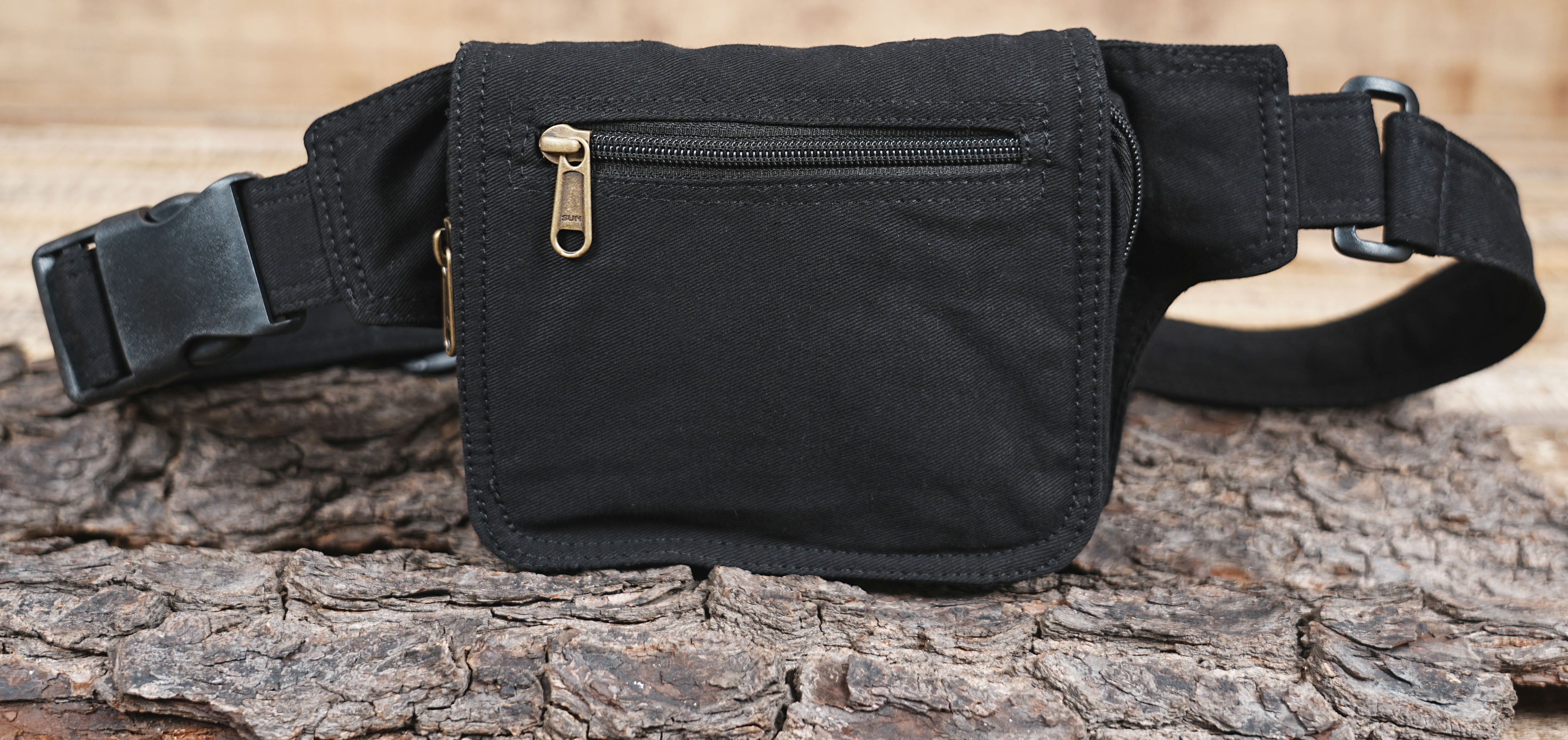 Durable black canvas fanny pack with a secure flap pocket and zip top.
