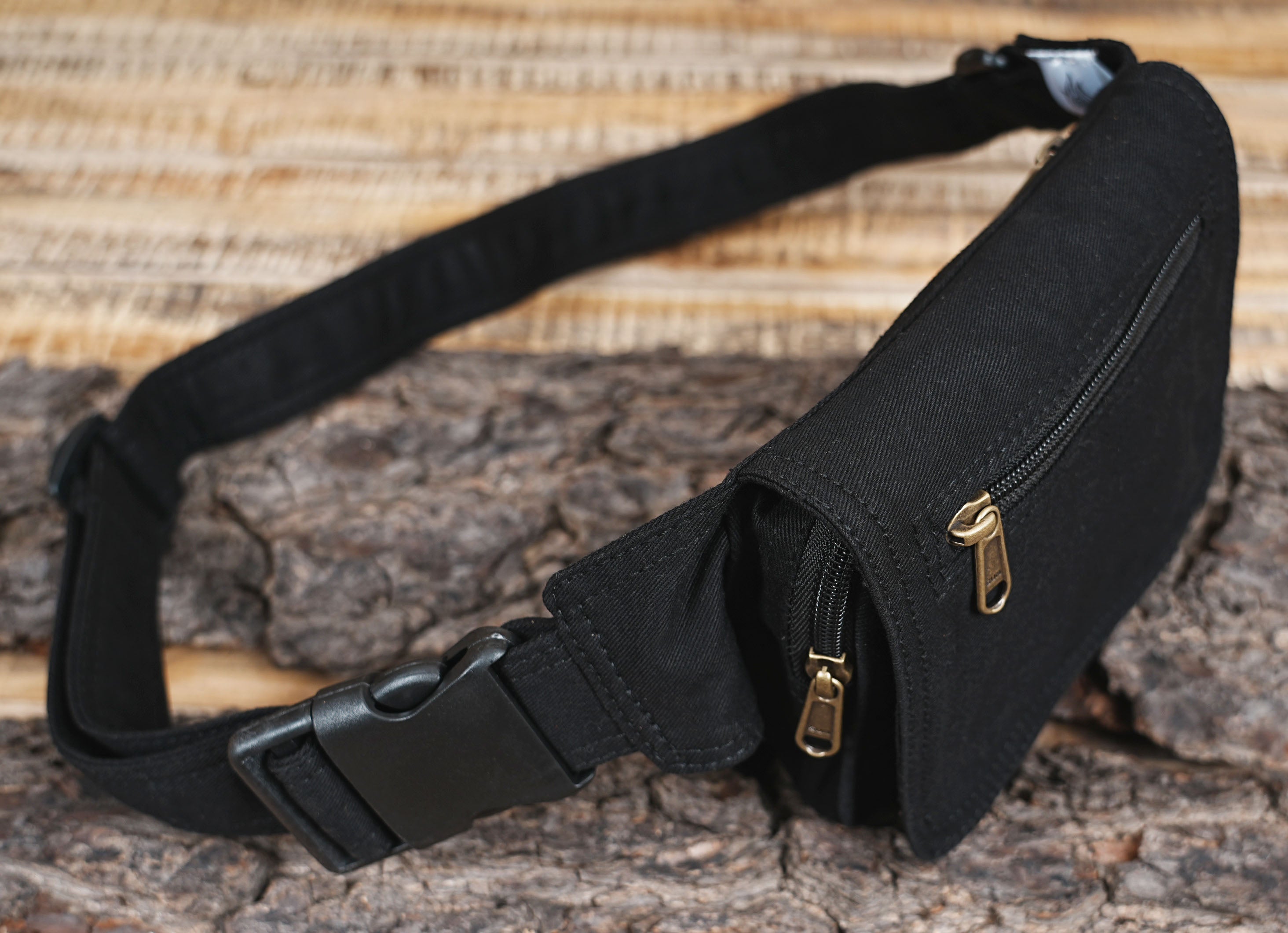 Unisex black hip belt bag featuring a sturdy buckle closure and woven strap.