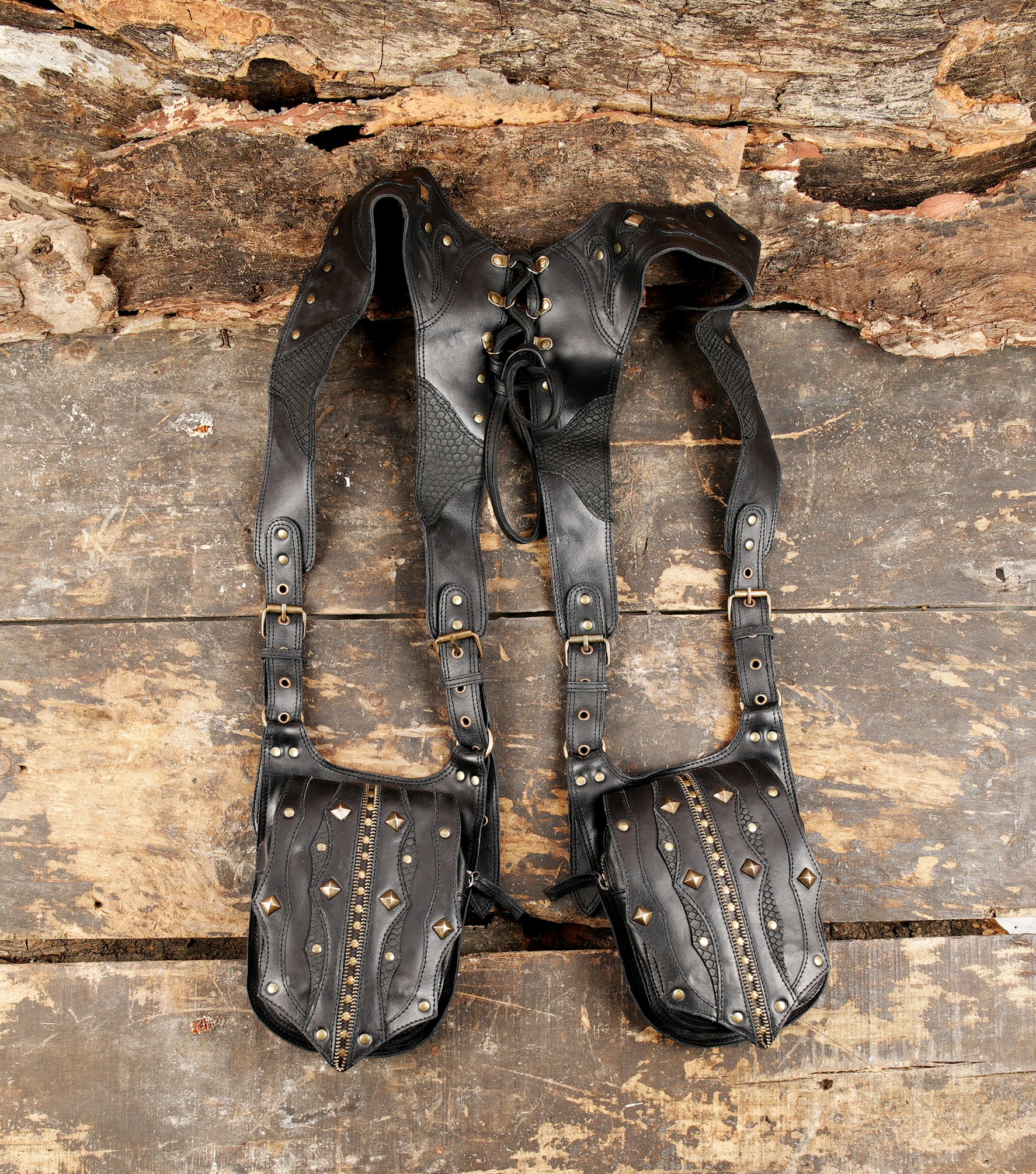 Black leather dual shoulder holster with brass studs and zipper detail