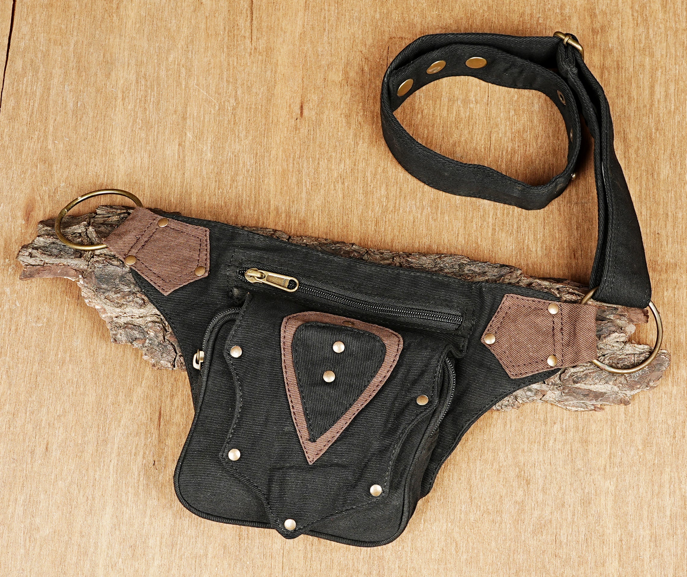 Alternative style bumbag with one main pocket, brown canvas accents, and heavy metal hardware.