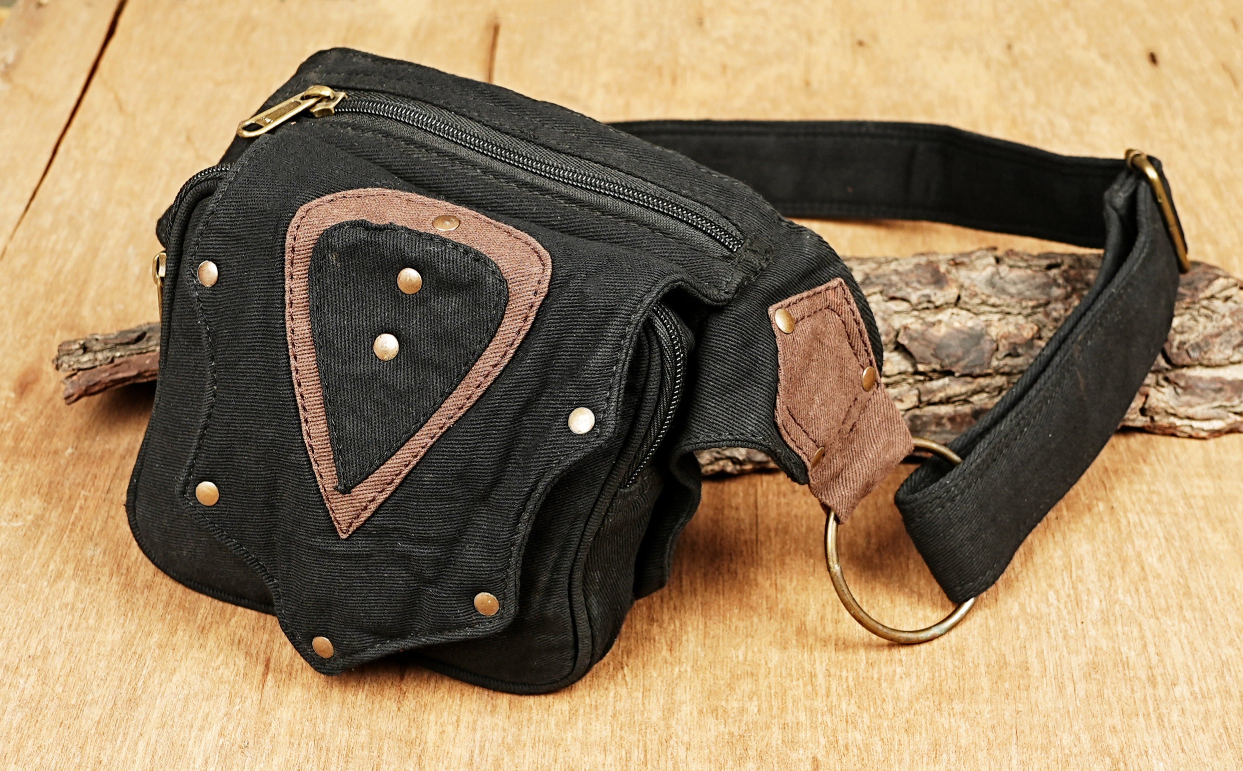 Versatile black canvas hip purse with a brown chevron detail and secure antique-gold zippers.