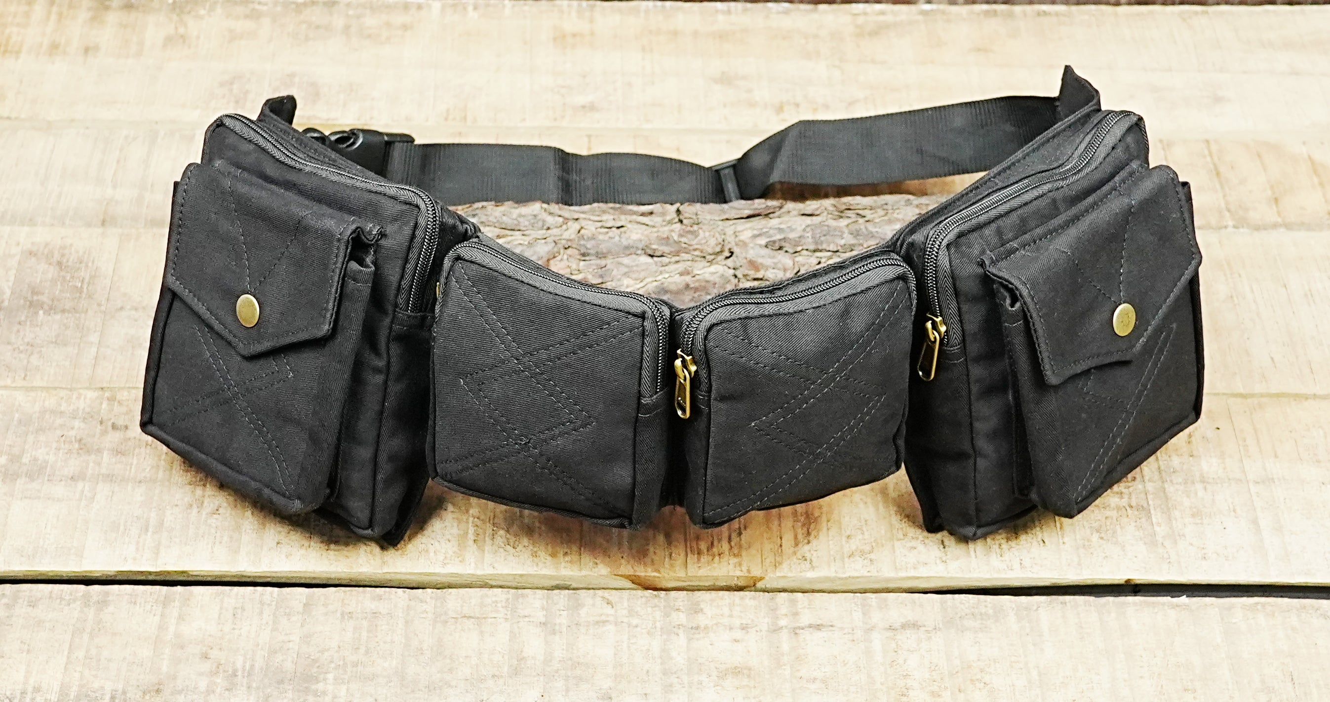 Festival fanny pack in durable black fabric laid flat on a wooden table