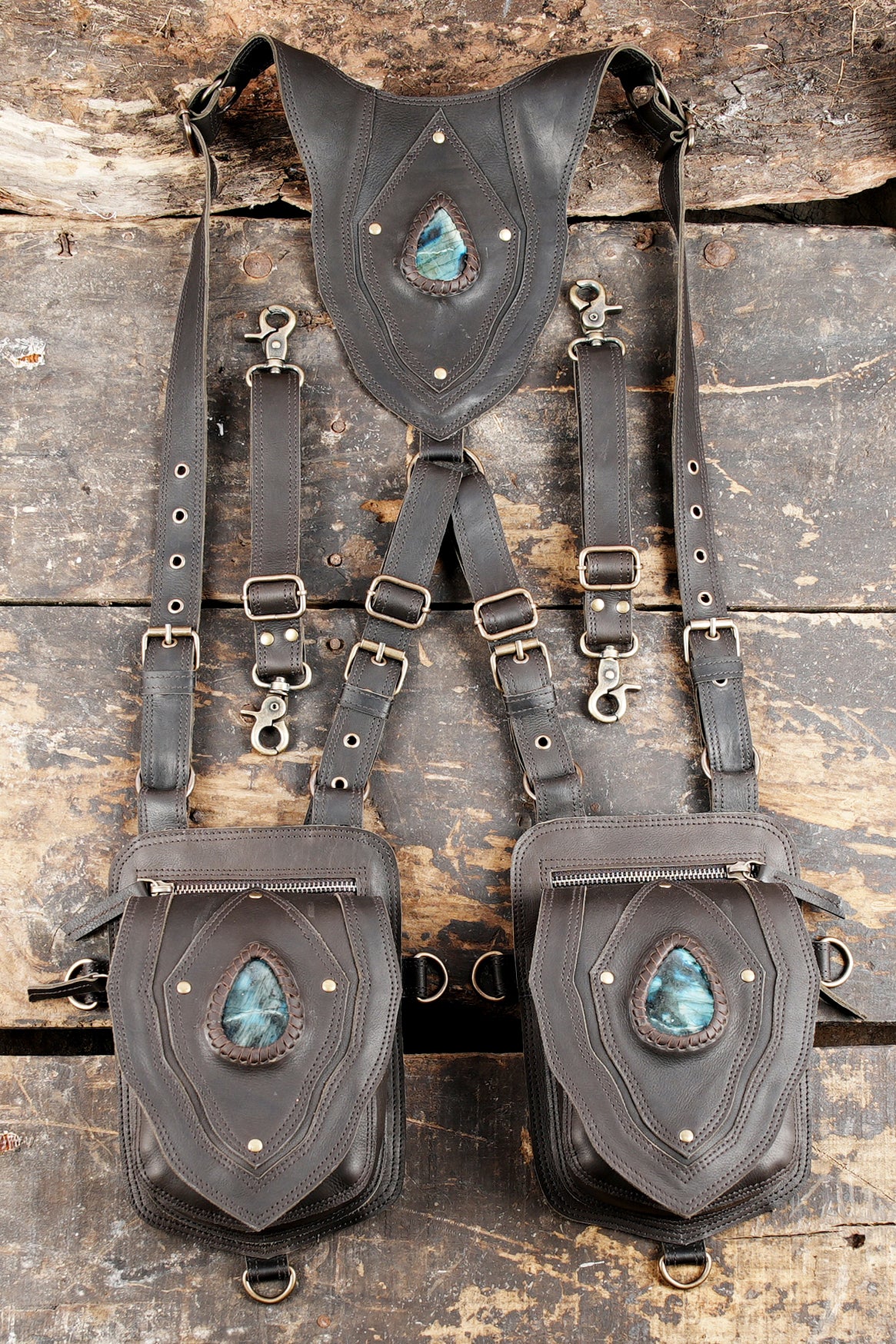 "Black leather holster harness with blue gemstone centerpiece"