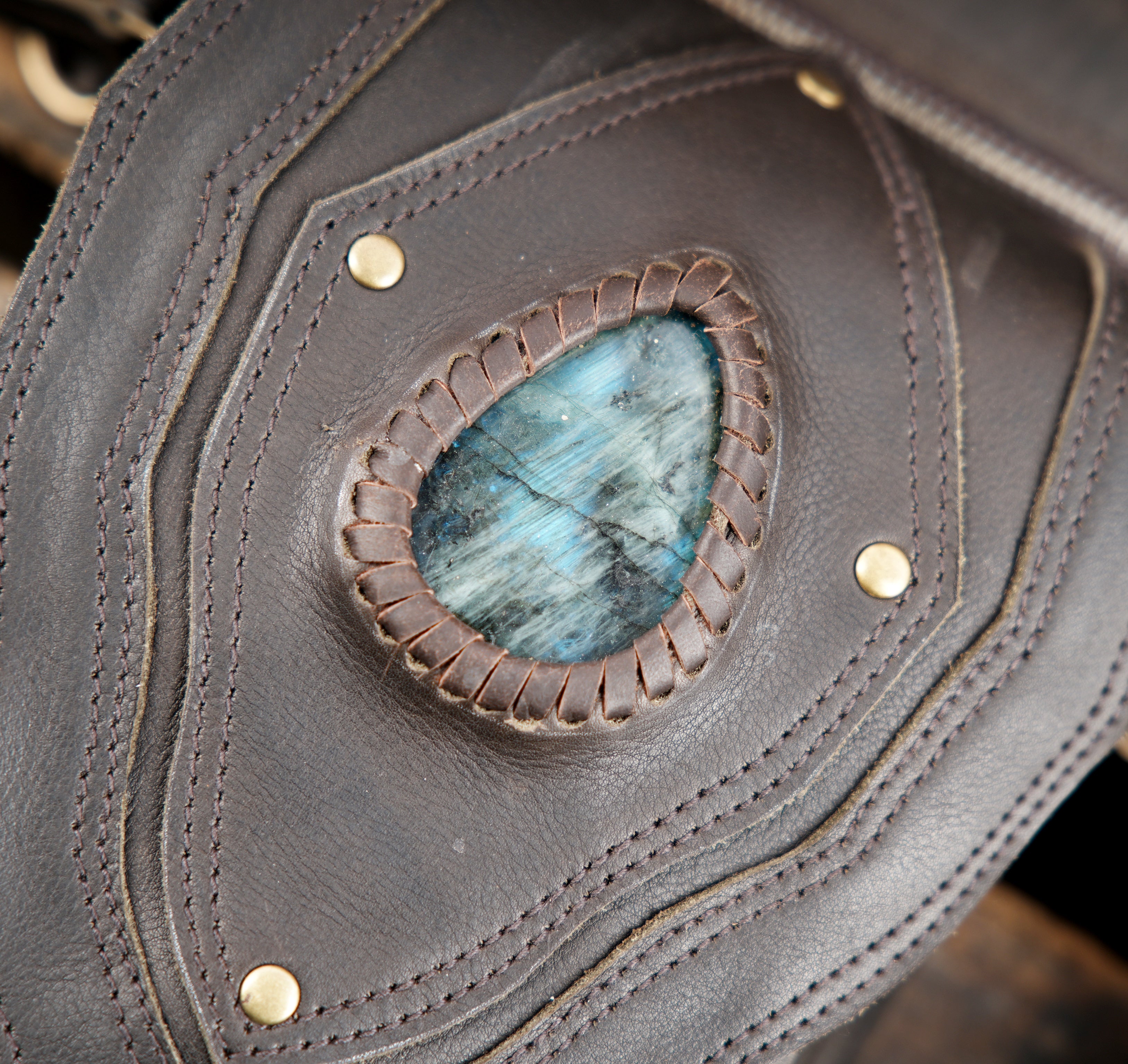 "Handcrafted leather holster bag with decorative blue stone"