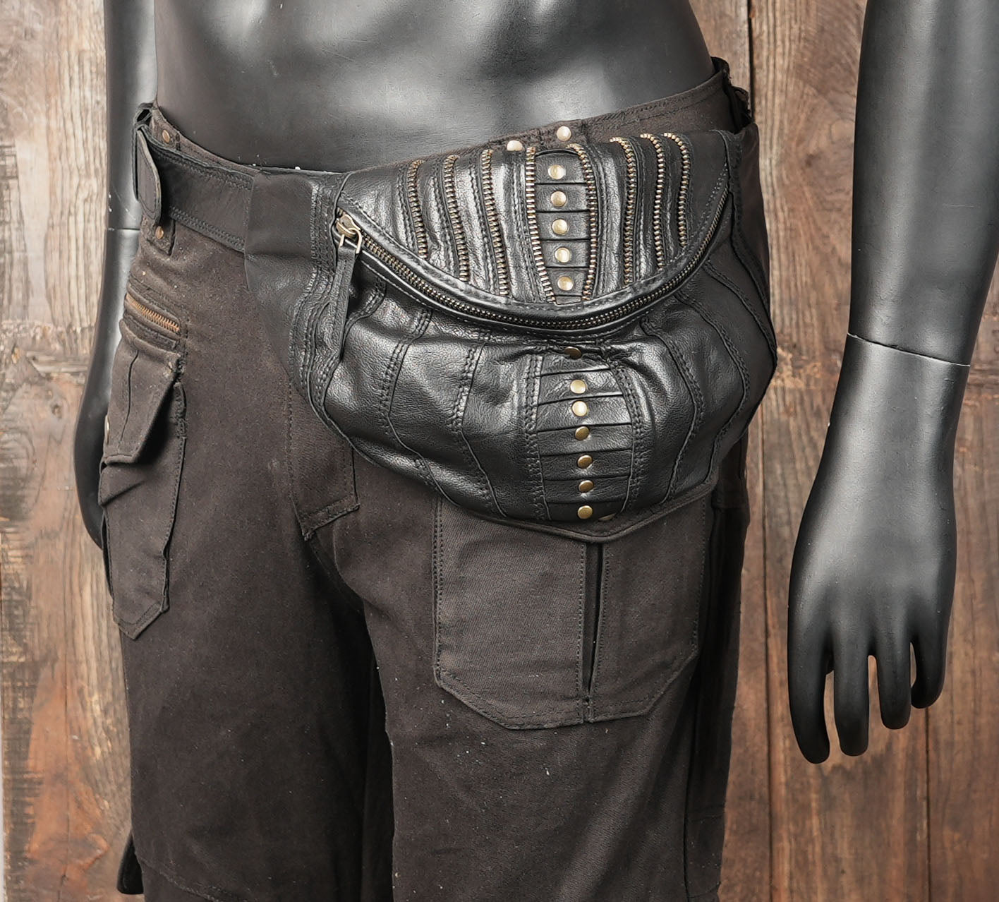 Handmade black leather utility belt with wide strap and antique rivets.