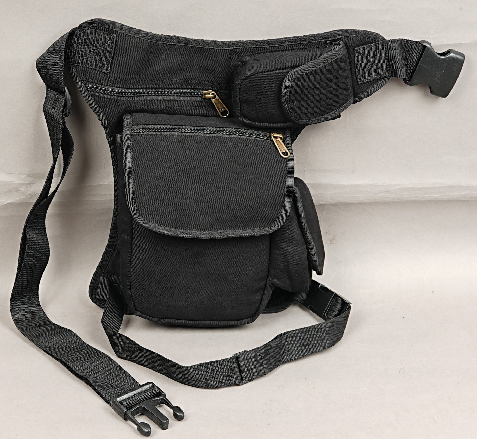 Black bohemian festival waist belt bag with adjustable leg fastener and side pouch.
