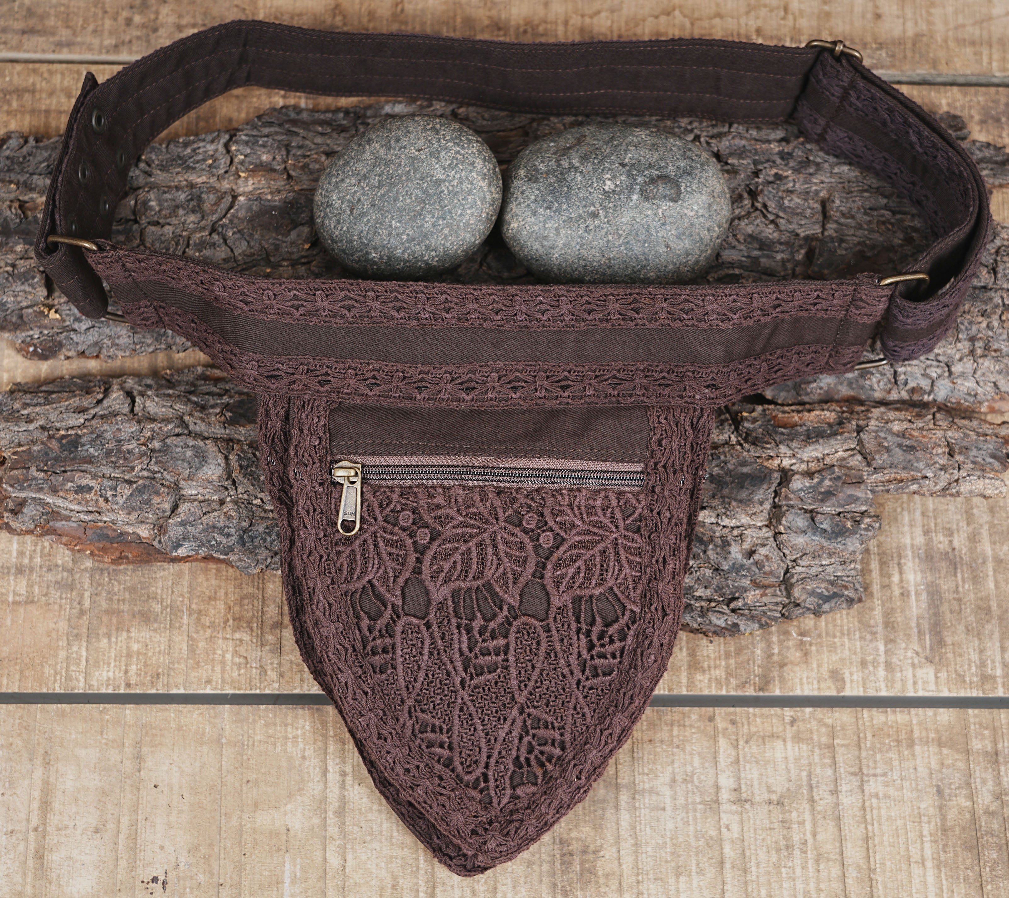 Handcrafted brown cotton utility belt with zipper pockets on rustic wood