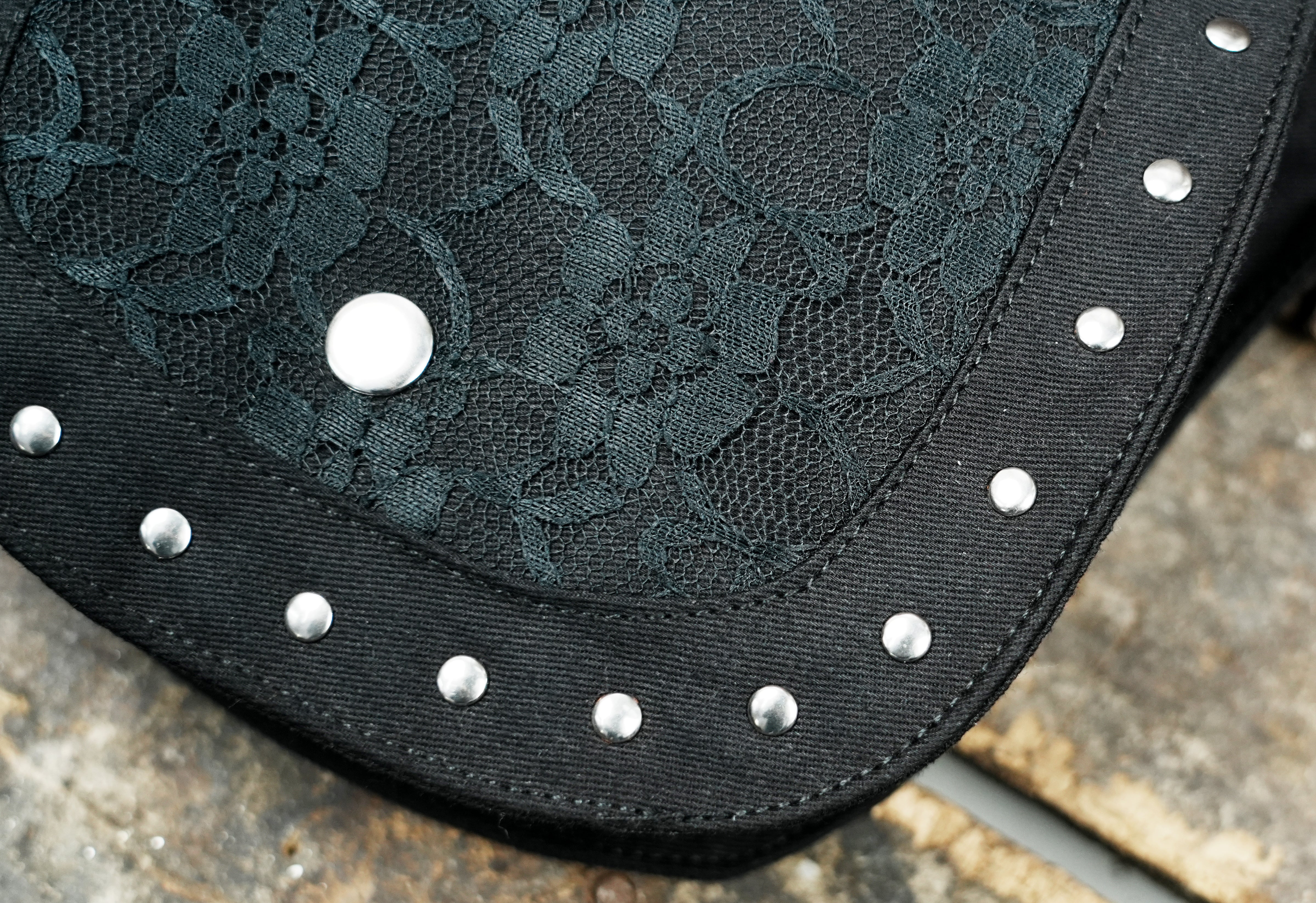 Hands-free utility pouch: black canvas fanny pack with studded and laced details.