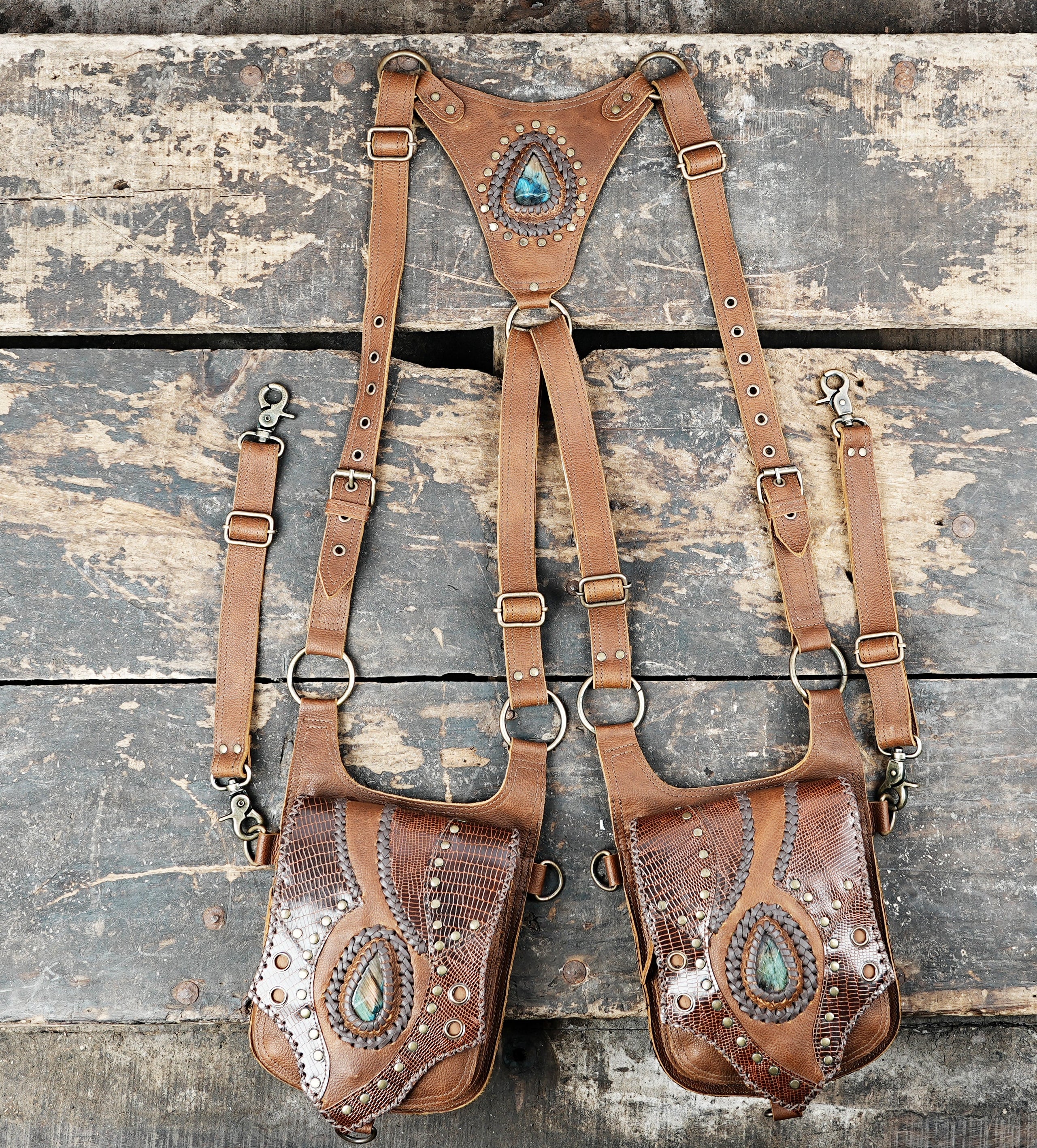 “Brown leather double holster with gemstone centerpiece and reptile textured panels”