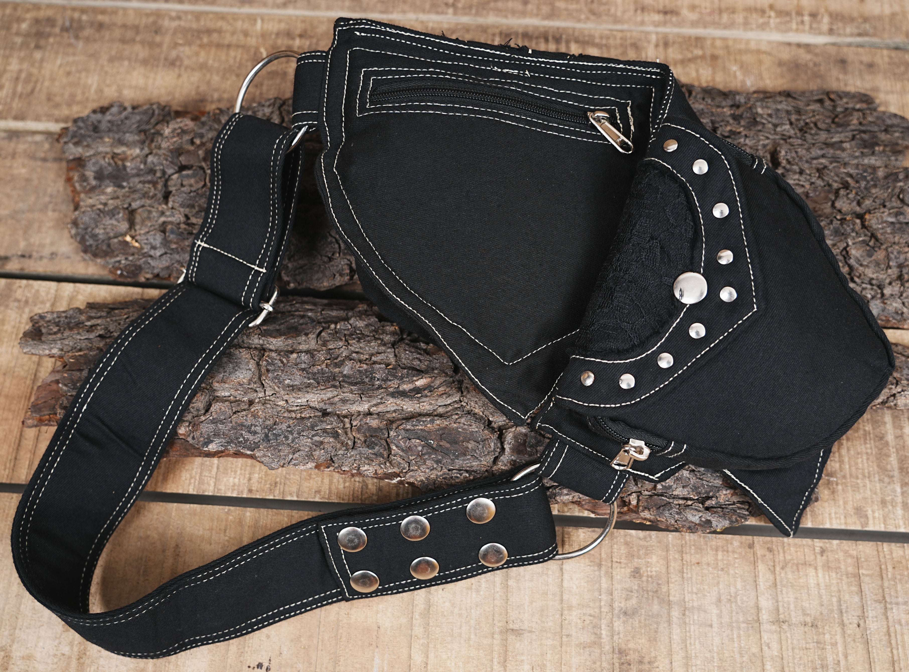 Black cotton canvas fanny pack with contrast white stitching and multiple zippered pockets.
