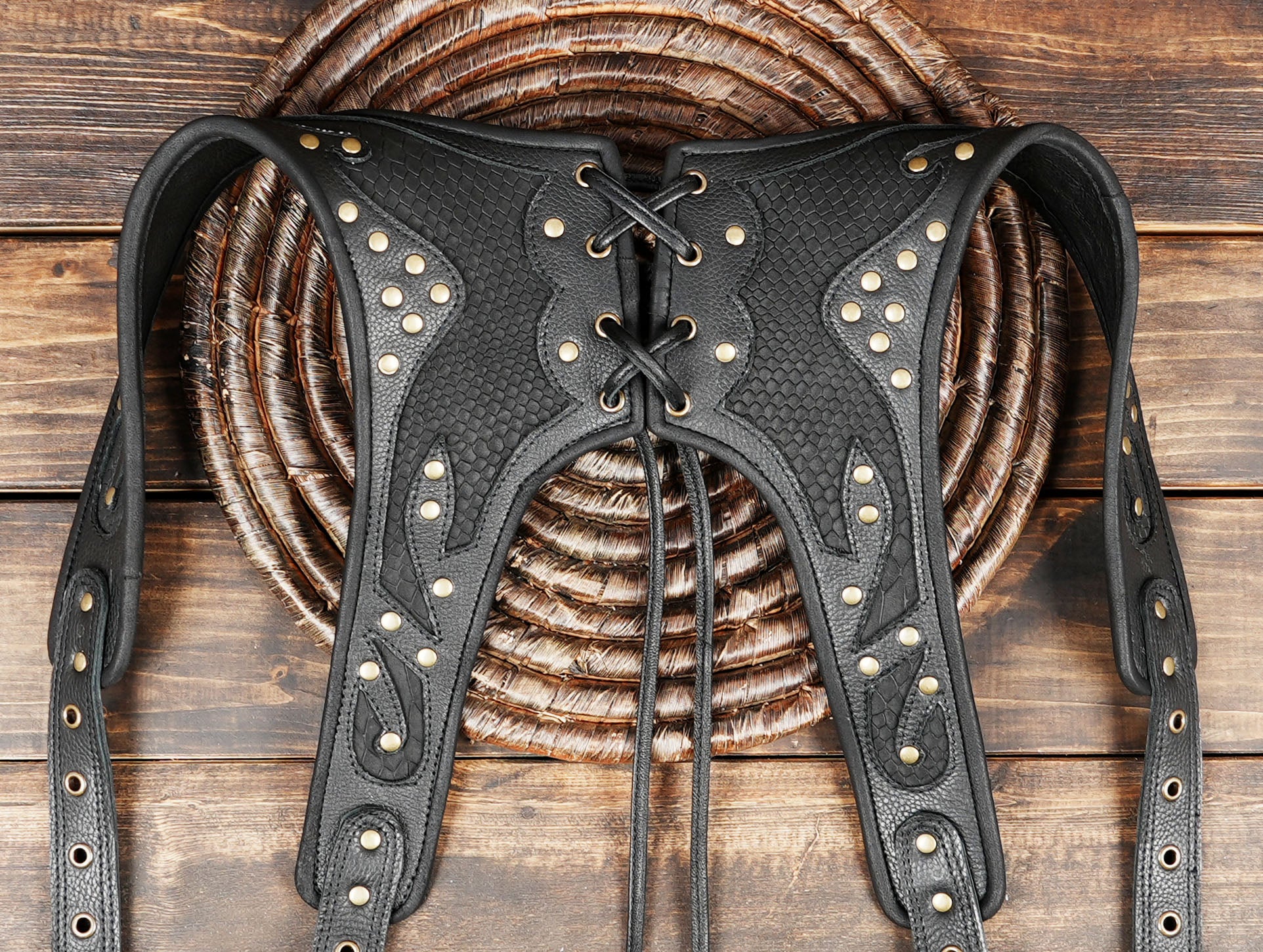 Close-up of gemstone inlaid in black leather harness bag with black steel metal 
