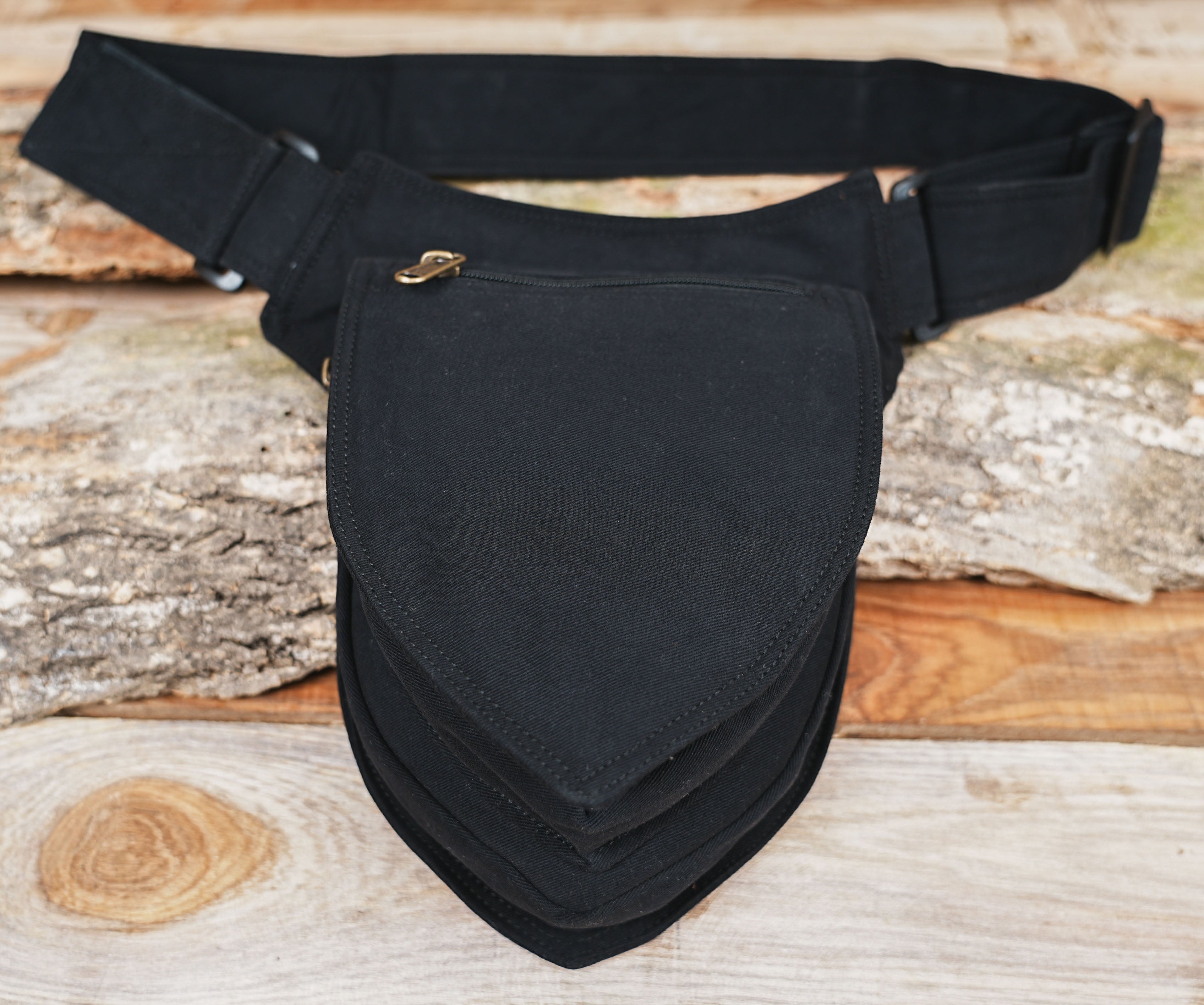 Close-up of black belt bag with brass zipper detail