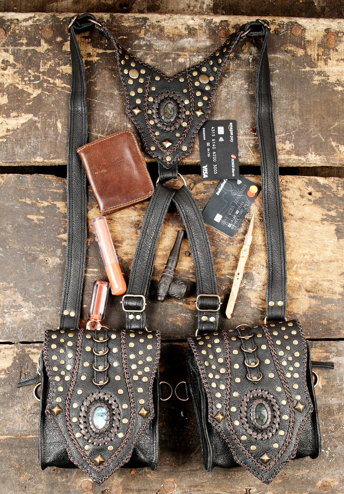 “Double pouch black leather holster with ornate stone accents”