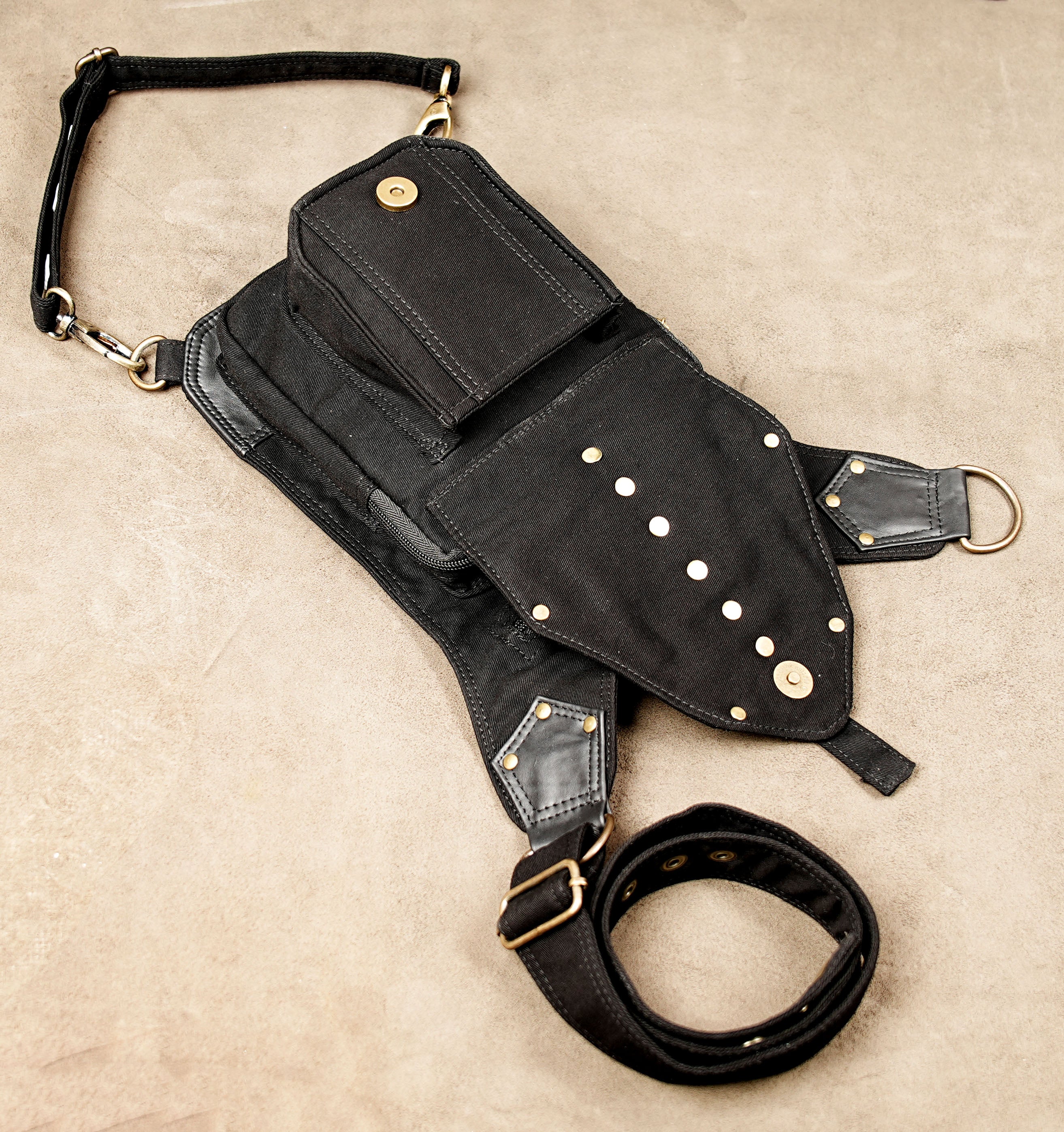 Alternative streetwear side pouch bag in canvas with brass ring detailing.