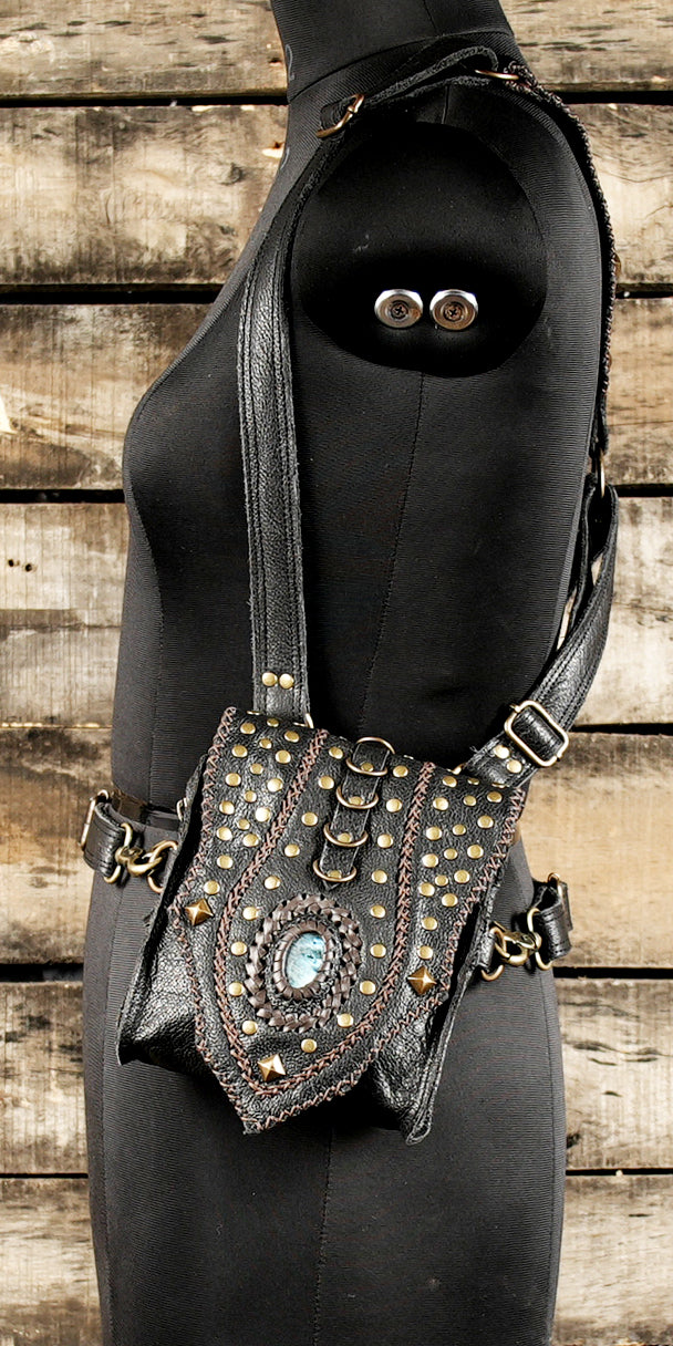 “Black leather holster harness with artisan craftsmanship and gemstone detail”