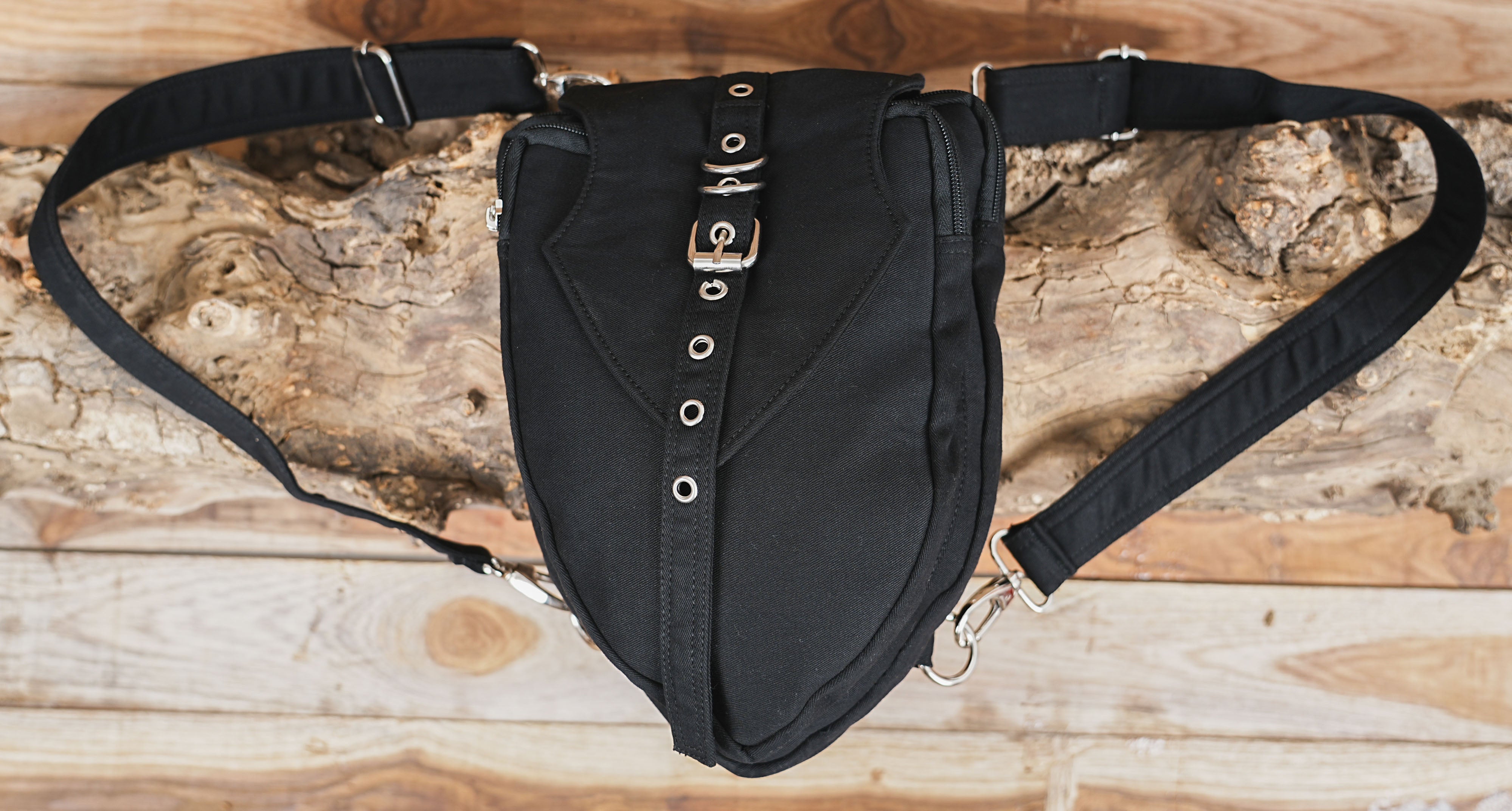Shoulder belt bag featuring a front buckle strap and metal eyelet details