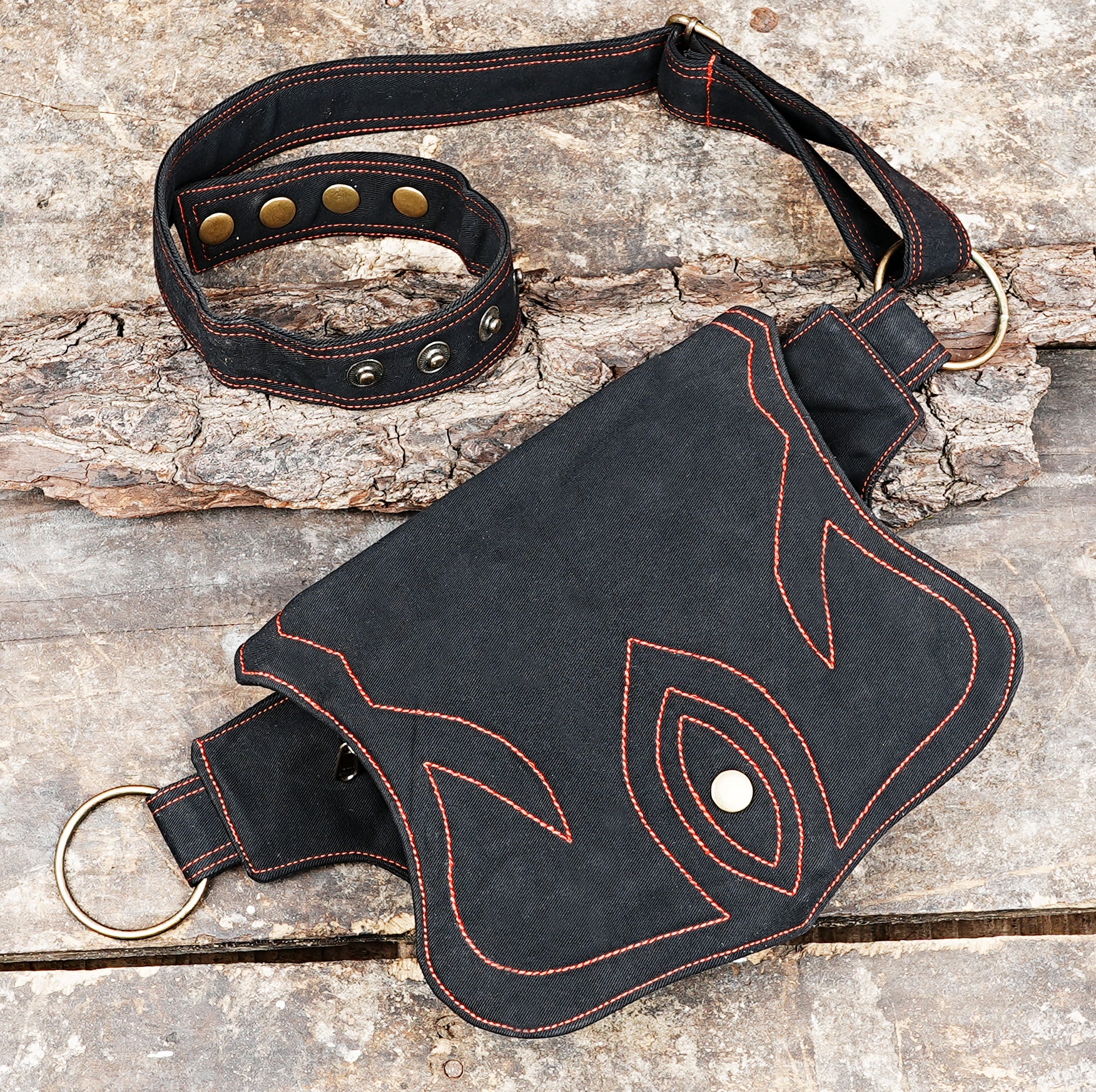 Rugged black belt bag with orange stitch pattern, worn crossbody or waist
