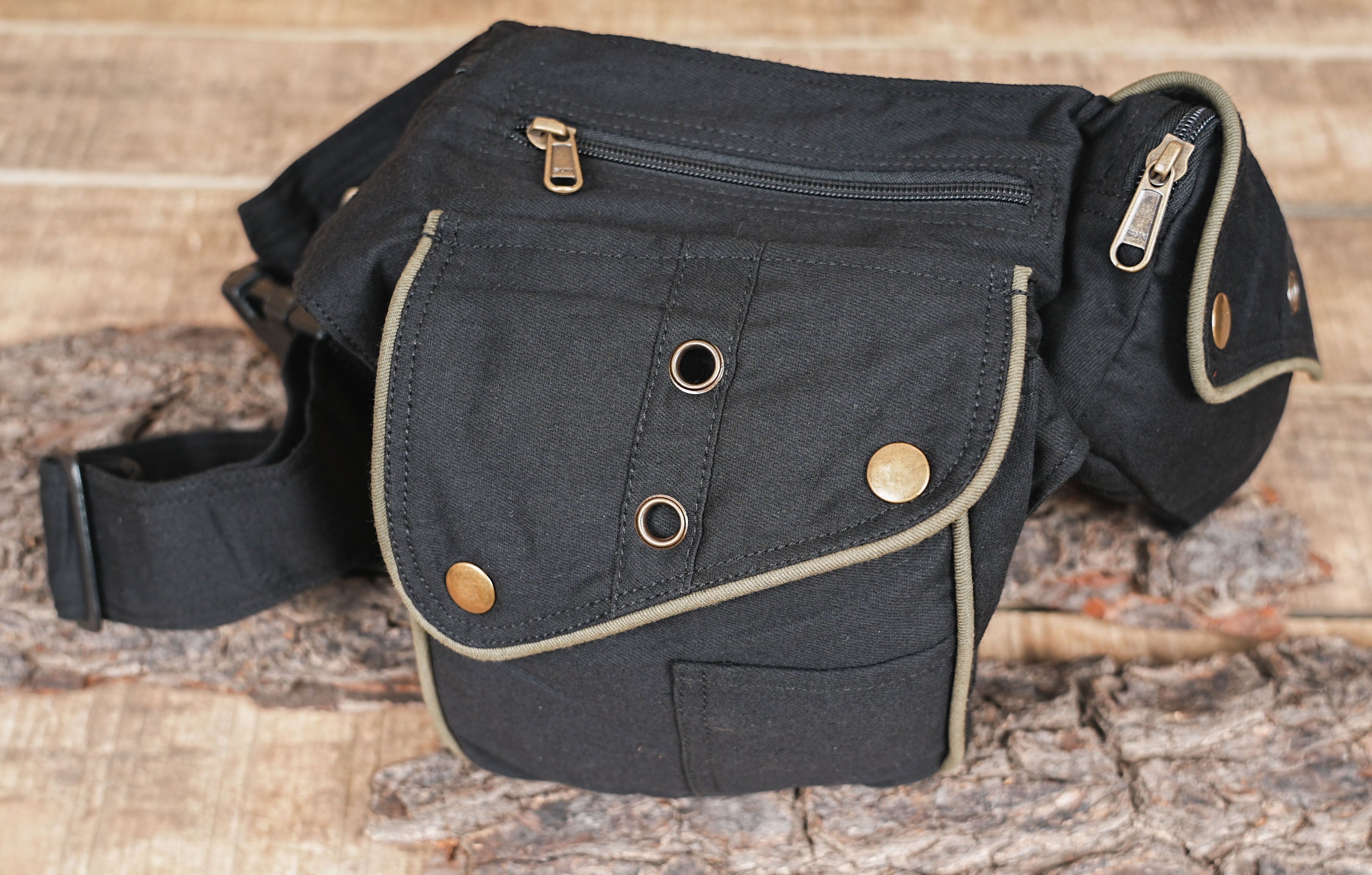 The front of a black festival belt bag highlighting the metal eyelets and strap adjusters.